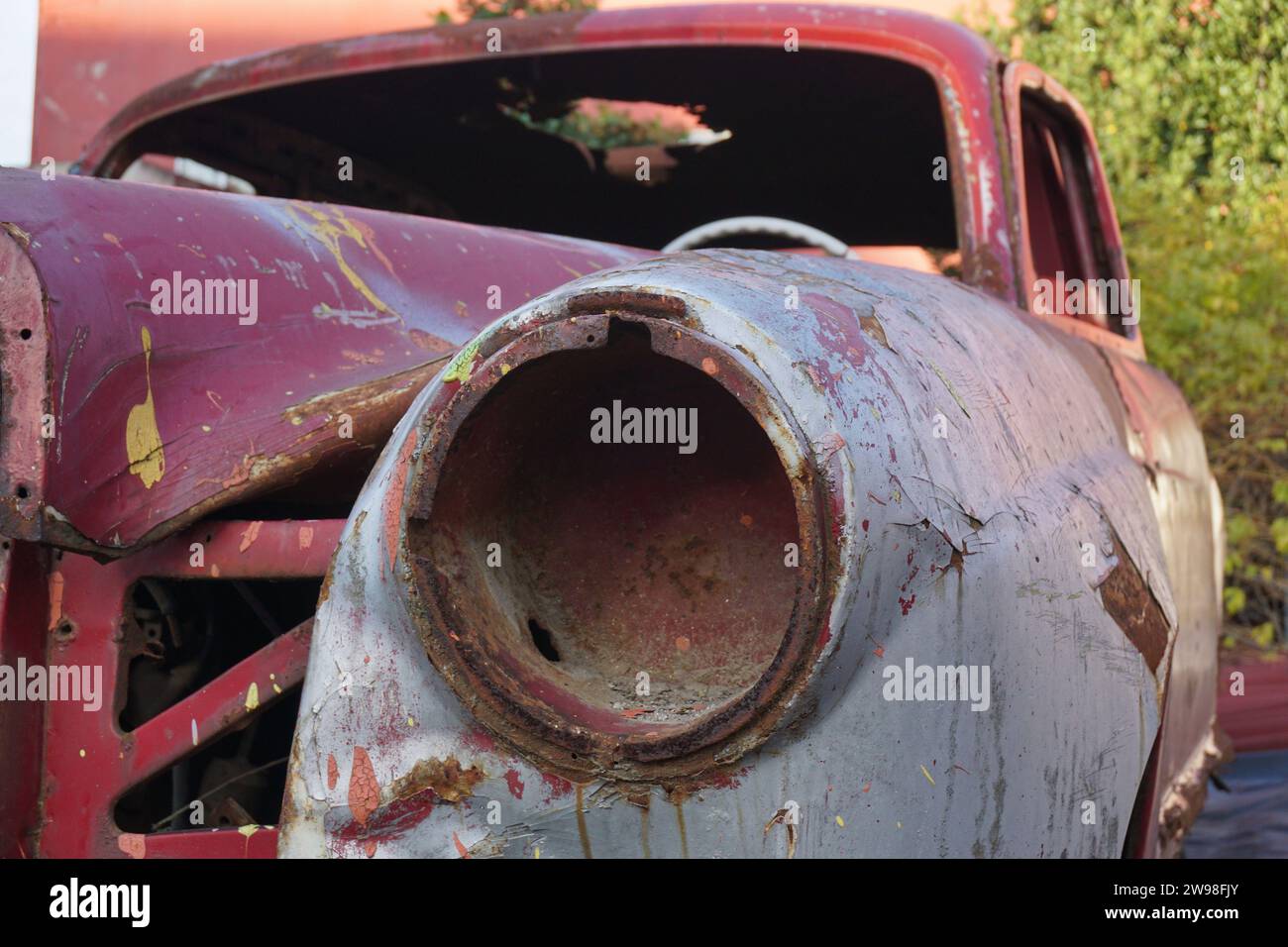 Ein verlassener klassischer rostrostiger Wagen, demontierter Scheinwerfer des Autos Stockfoto