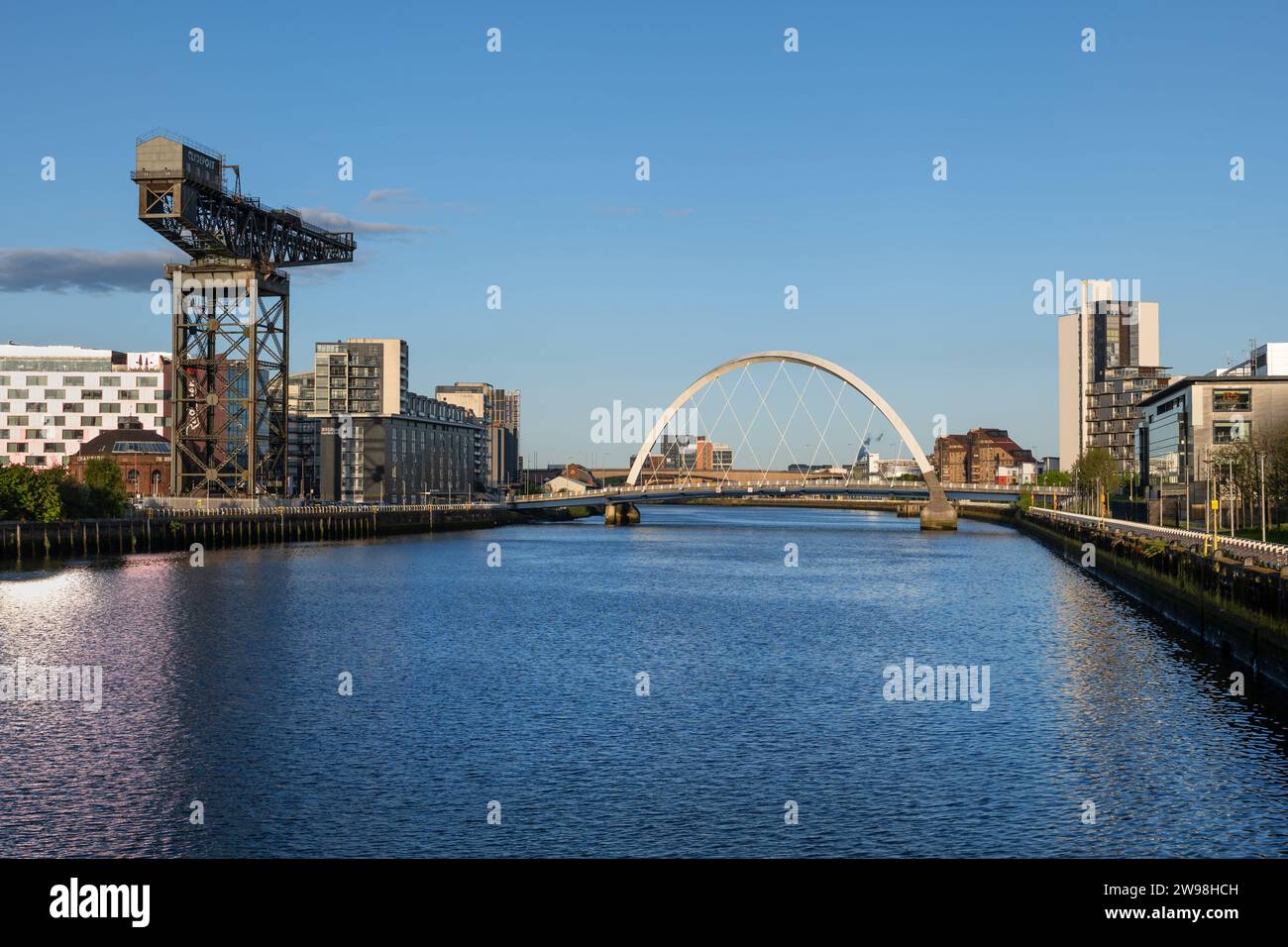 Skyline mit Finnieston Crane und Clyde Arc Bridge am Fluss Clyde bei Sonnenuntergang in Glasgow in Schottland, Großbritannien. Stockfoto