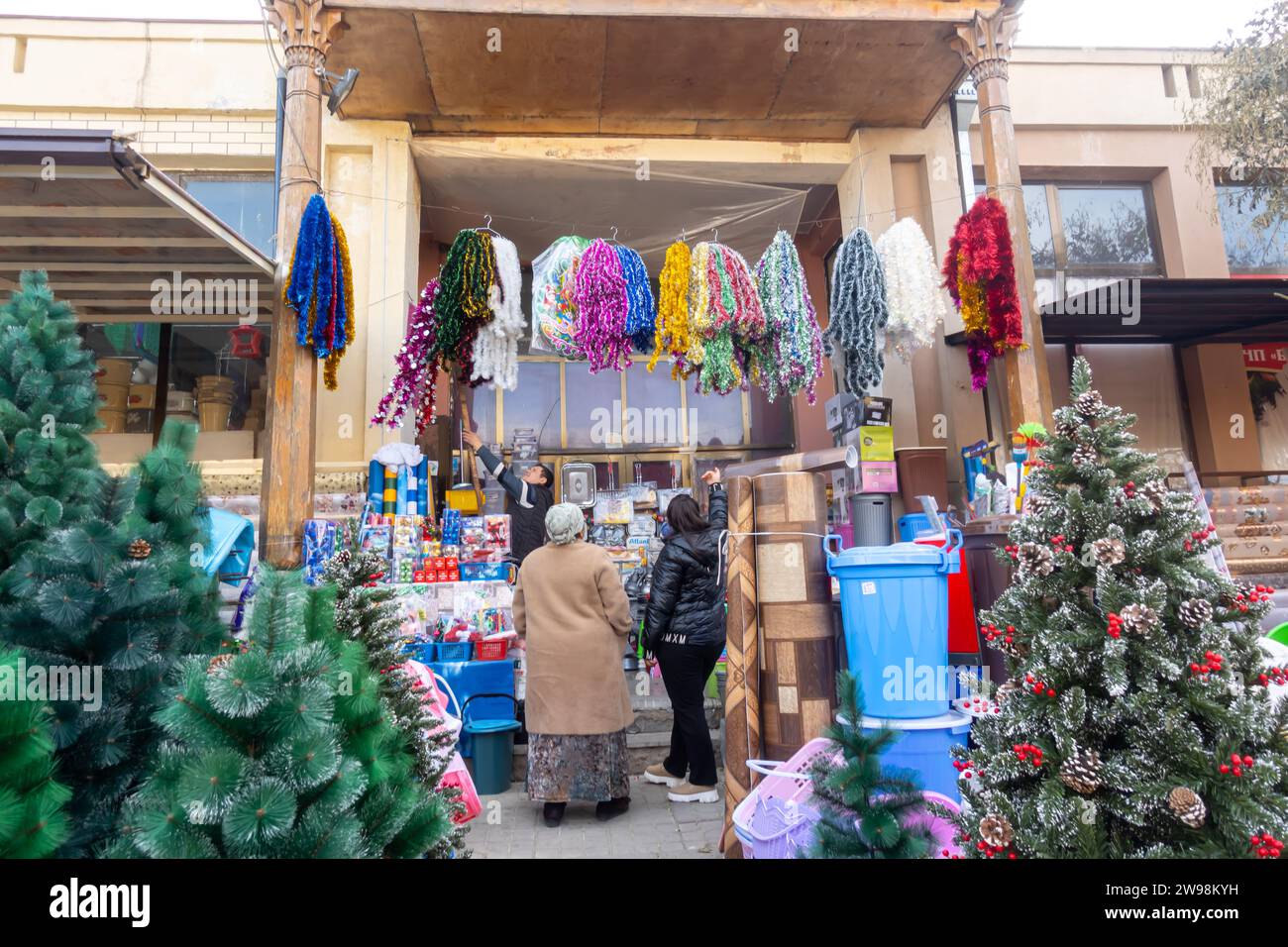 Käufer kaufen Weihnachtsdekoration an den Ständen des Siyob Basars mit einem Weihnachtsbaum Samarkand Usbekistan Stockfoto