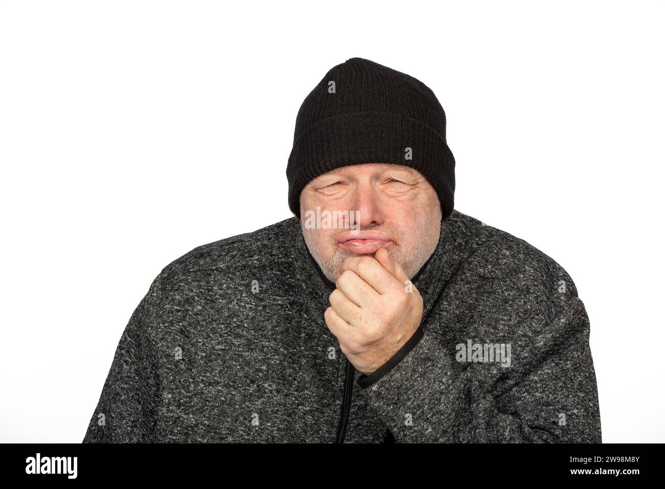Kontemplativer Arbeiter mittleren Alters in schwarzem Winterhut auf weißem Hintergrund Fühlen Sie die Kälte Stockfoto