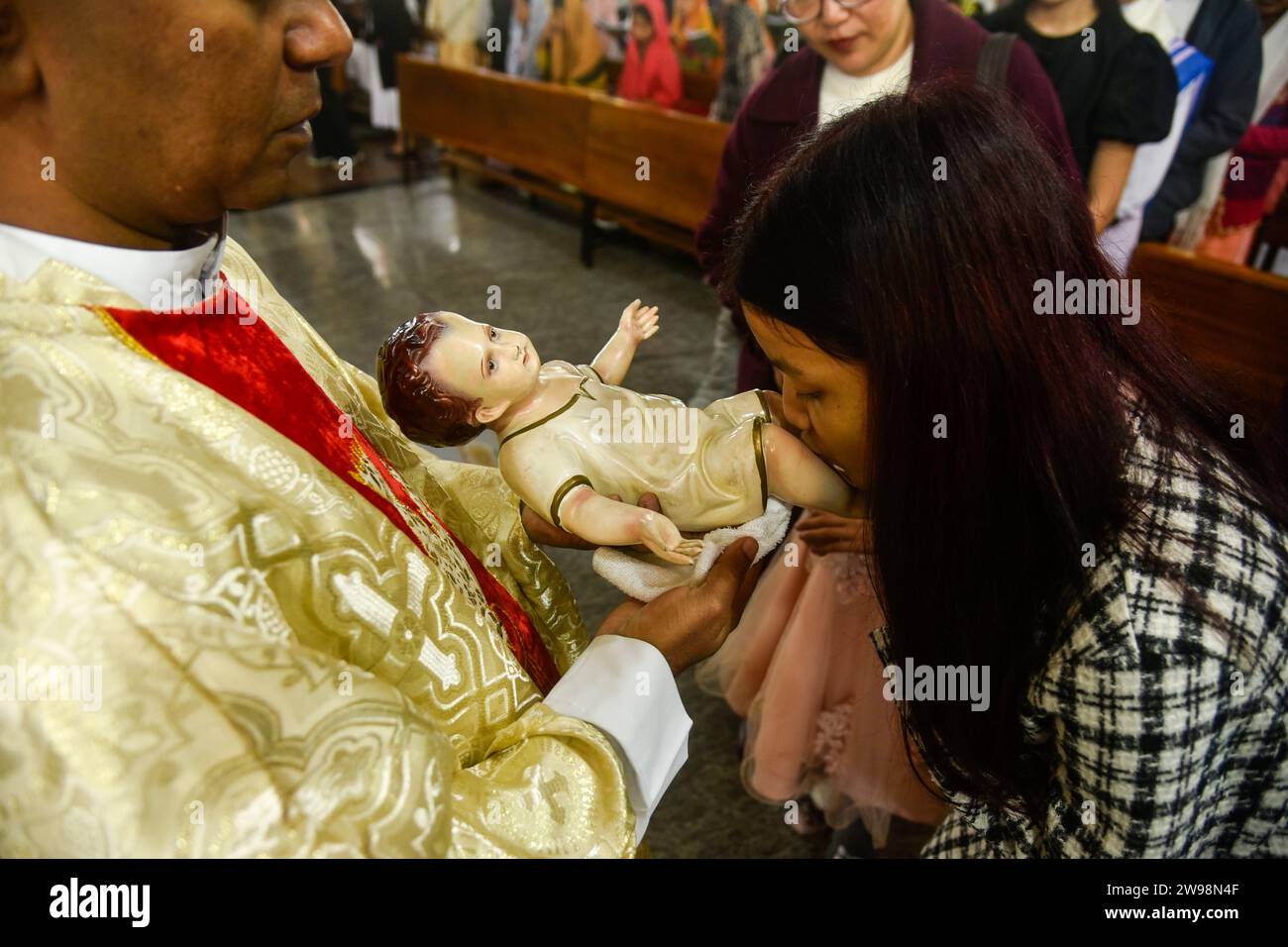 GUWAHATI, INDIEN - 25. DEZEMBER: Gläubige küssten das kleine Idol Jesu Christi anlässlich der Weihnachtsfeier in der katholischen Kathedrale Dispur Kirche in Guwahati, Indien am 25. Dezember 2023. Stockfoto