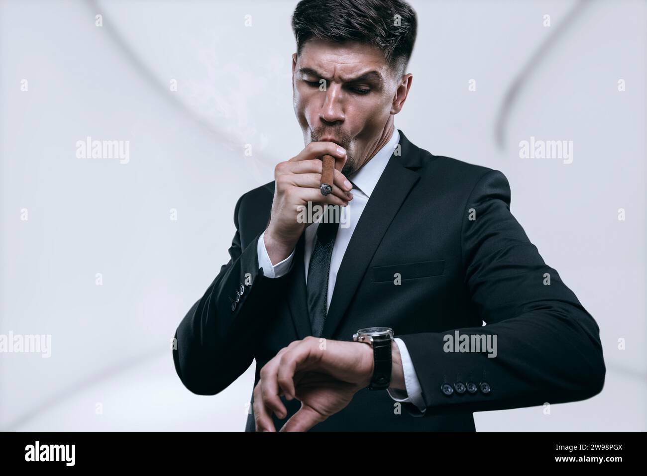 Porträt eines stilvollen Mannes in einem Anzug mit einer Zigarre. Geschäftskonzept. Gemischte Medien Stockfoto