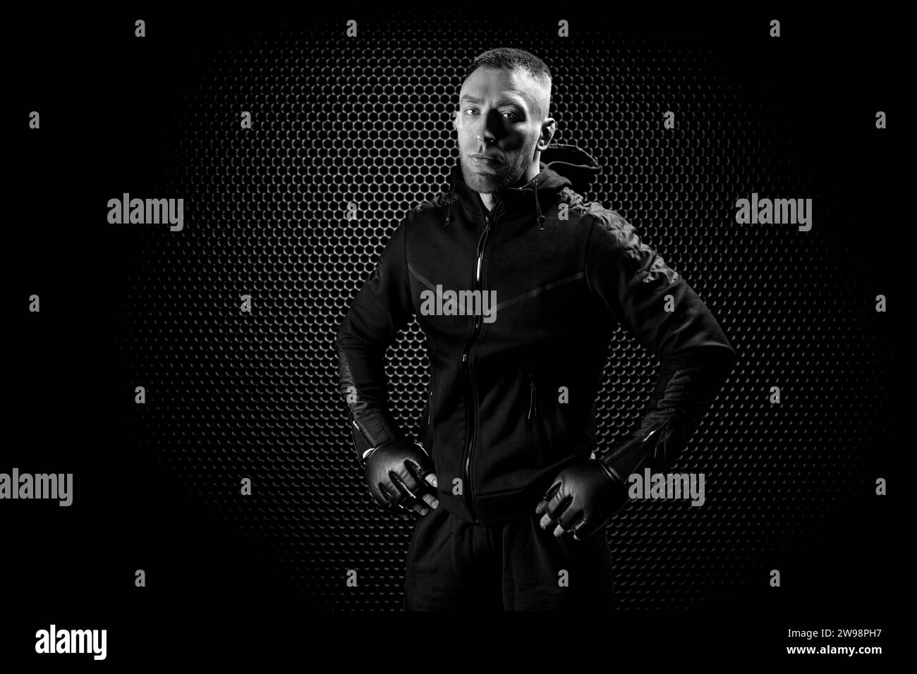 Mixed Martial Arts-Kämpfer posiert auf einem Gitter-Hintergrund. Konzept von mma, ufc, thai-Boxen, klassischem Boxen. Gemischte Medien Stockfoto