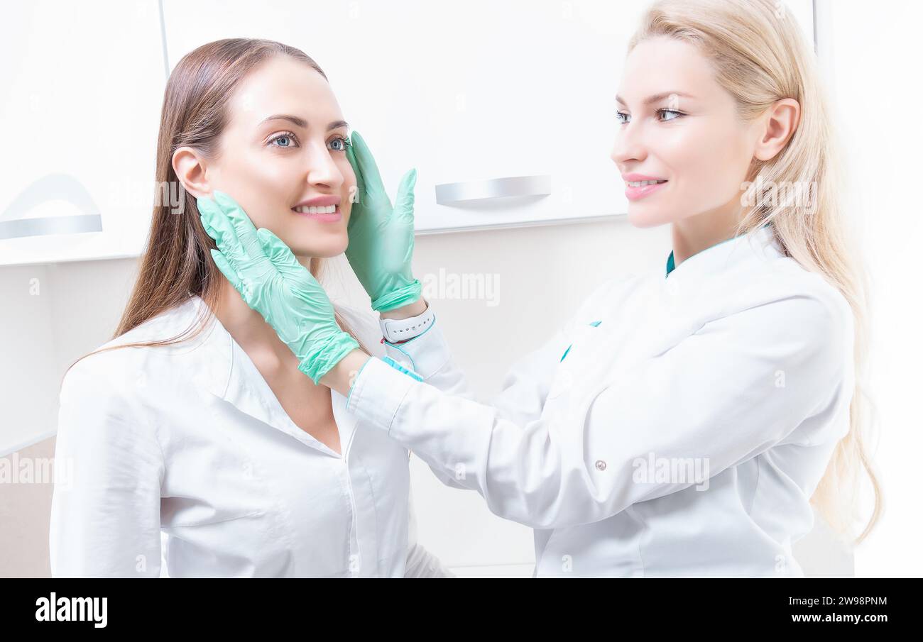 Schönes Mädchen bei einer Beratung im Salon mit einem plastischen Chirurgen. Konzept der Kosmetikbranche. Gemischte Medien Stockfoto