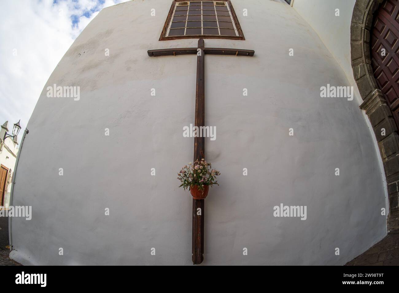 Kreuz mit Blumen an der Wand der Kirche Santa Ana (Iglesia de Santa Ana). Kleine Stadt Garachico. Teneriffa. Kanarische Inseln. Spanien. Stockfoto