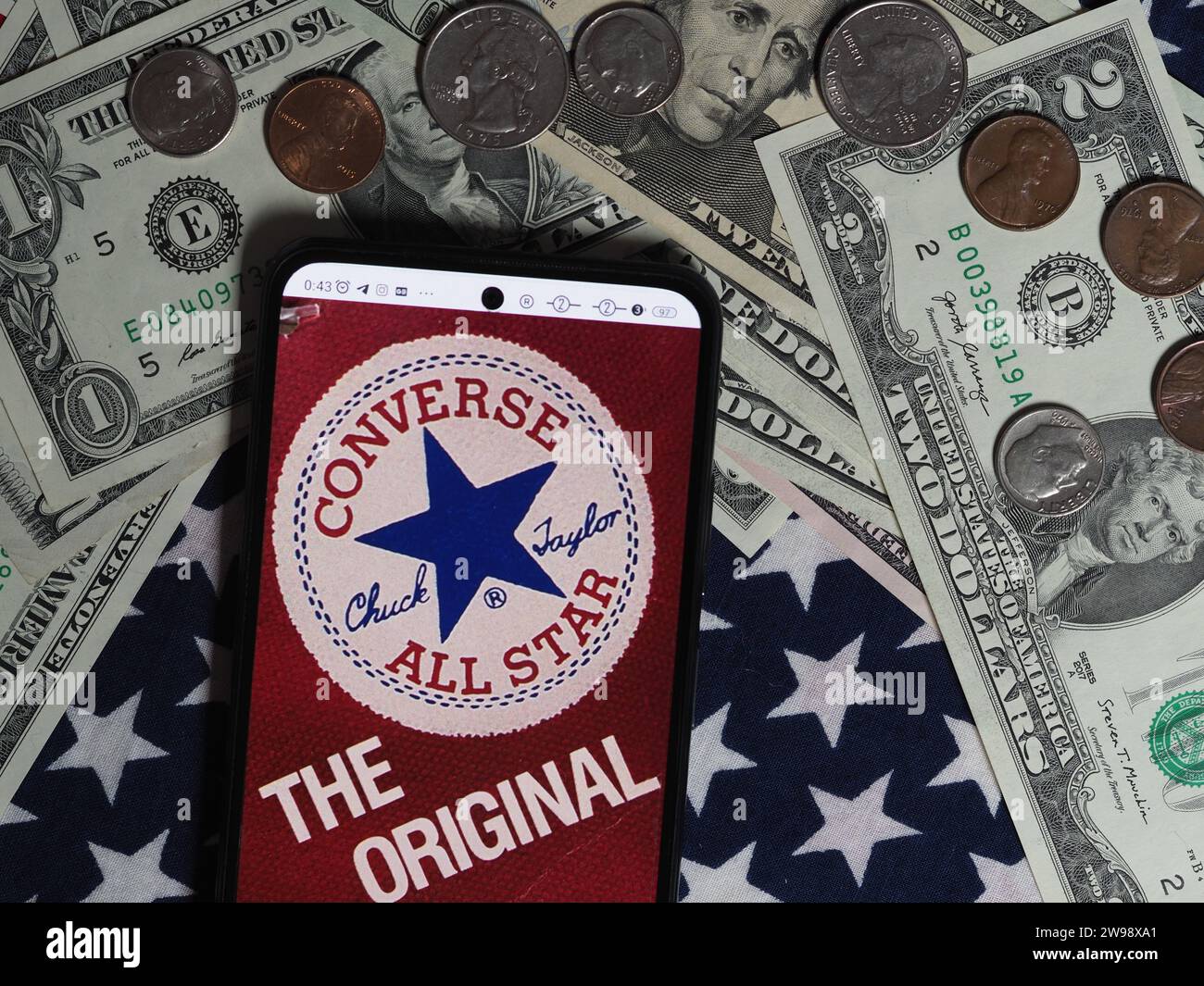 Deutschland. Dezember 2023. In dieser Fotoabbildung ist ein Chuck Taylor All-Stars-Logo auf einem Smartphone mit US-Dollar-Banknoten und -Münzen im Hintergrund zu sehen. Quelle: SOPA Images Limited/Alamy Live News Stockfoto