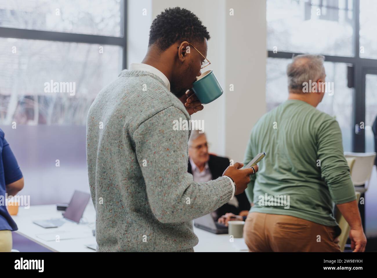 Männlicher, schwarzer Angestellter genießt seinen Tee während der Pause. Stockfoto