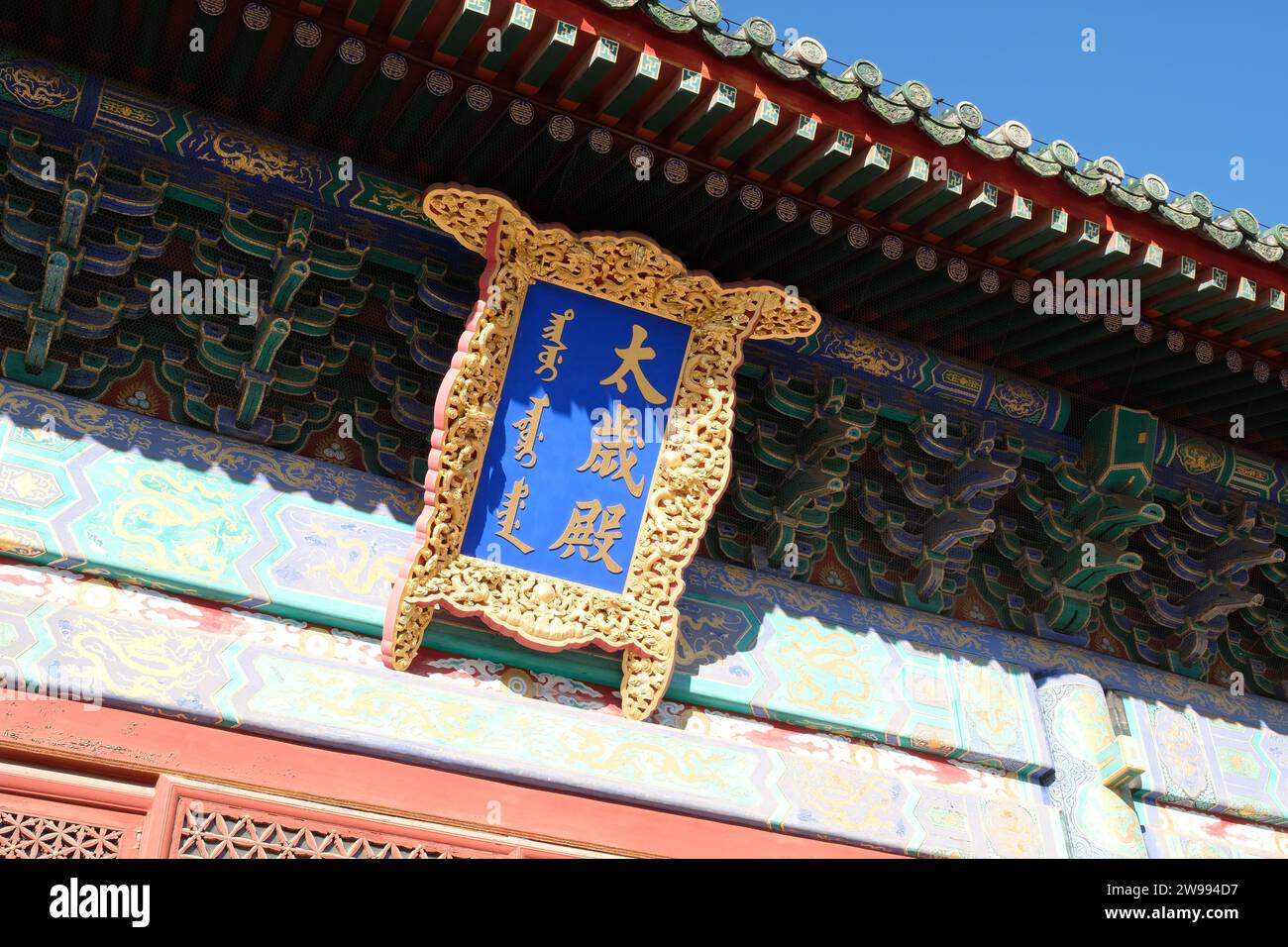 Ein abstrakter Blick aus der Luft auf ein blau-goldenes Dach mit blauen chinesischen Symbolen, die eine einzigartige und lebendige Perspektive bieten Stockfoto