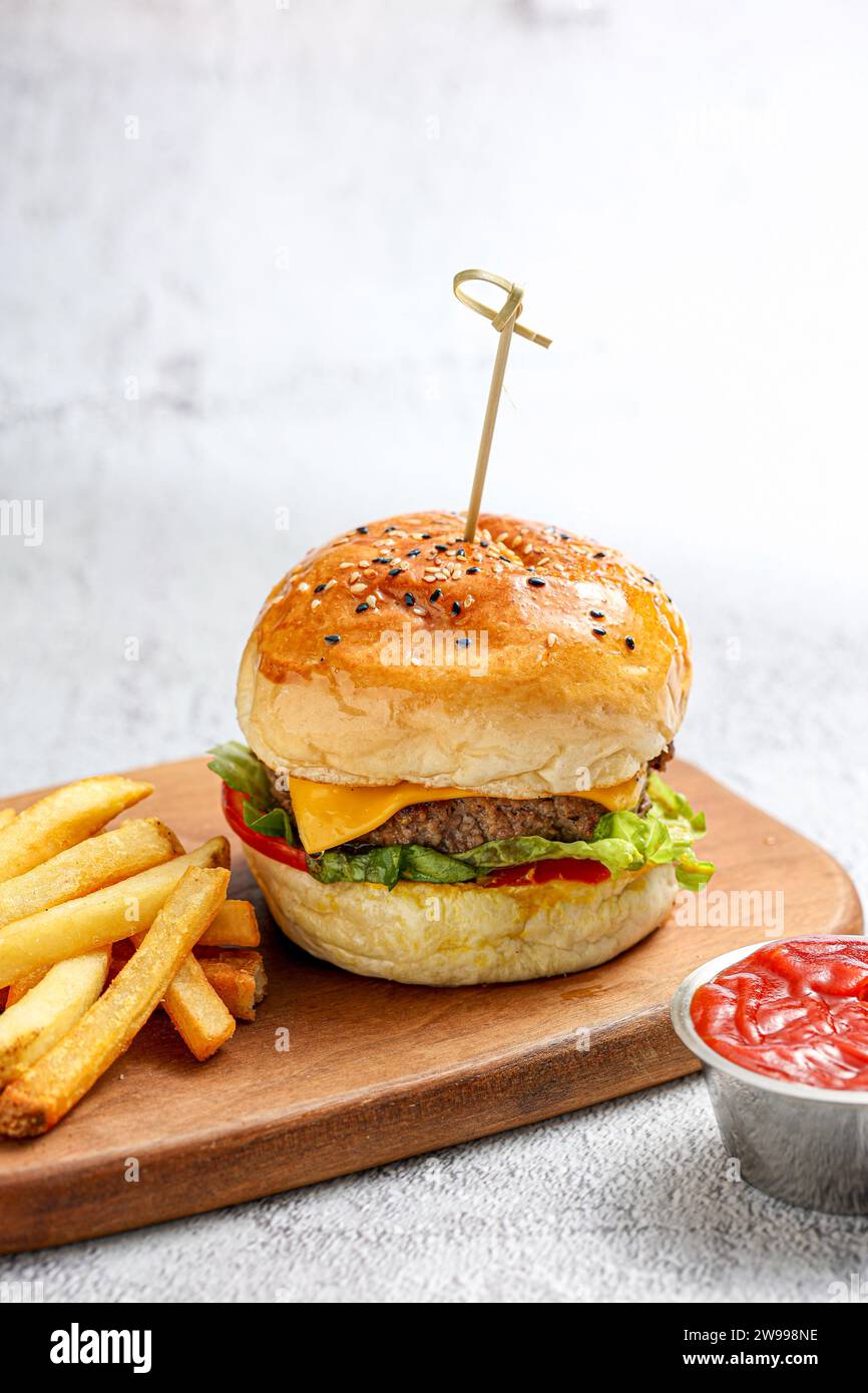 Bild eines einlagigen Burger-Sandwiches mit einer Seite Pommes Frites auf weißem Hintergrund Stockfoto