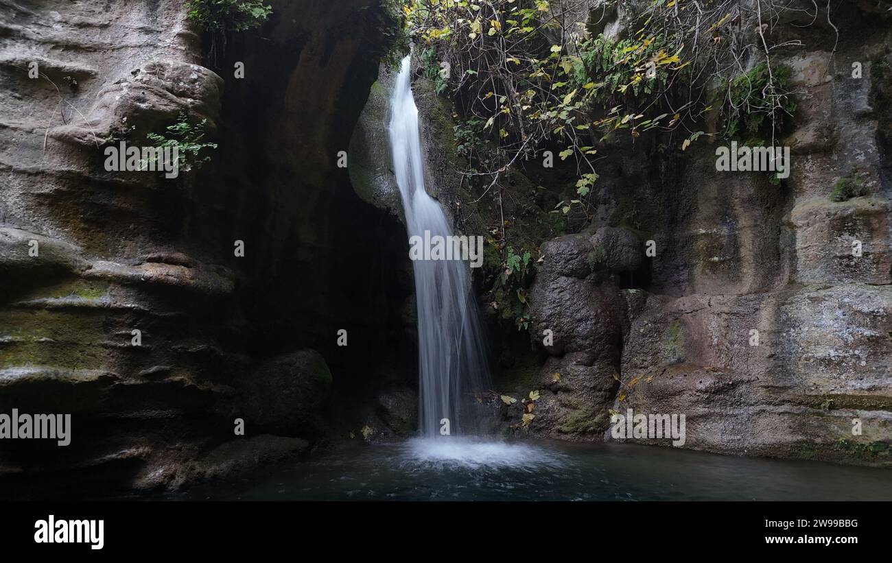 Ein majestätischer Wasserfall, der über einen schmalen Felsvorsprung fällt, mit einem ruhigen Pool darunter. Stockfoto