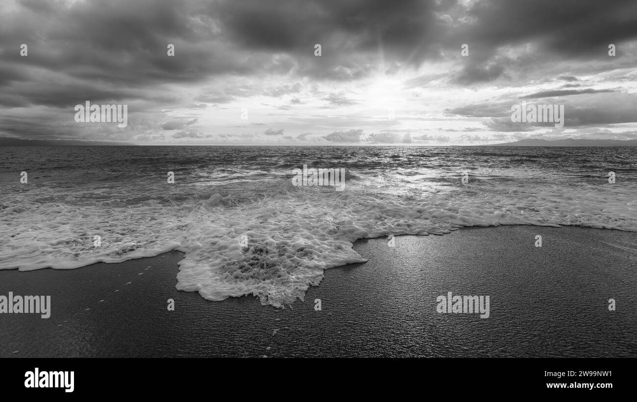 Eine Meereslandschaft Mit Goldenen Sonnenstrahlen, Die Durch Die Wolken Brechen 16:9 High Resolution Stockfoto