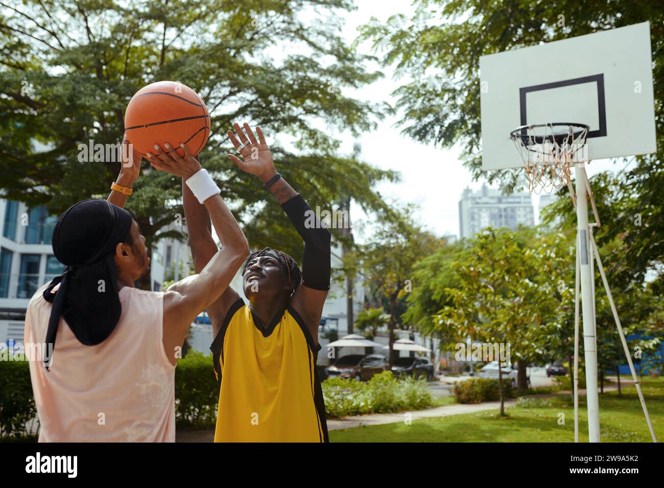 Junge Schwarze Männer spielen gerne im Freien Basketball Stockfoto