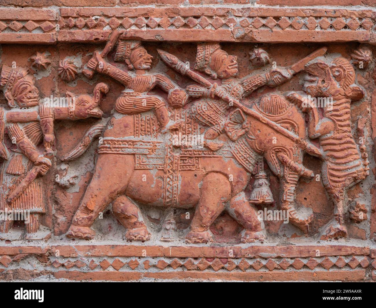 Nahaufnahme der geschnitzten Terrakotta-Jagdszene von Jägern auf Elefanten, die Tiger auf dem alten Govinda-Tempel in Puthia, Rajshahi, Bangladesch töten Stockfoto