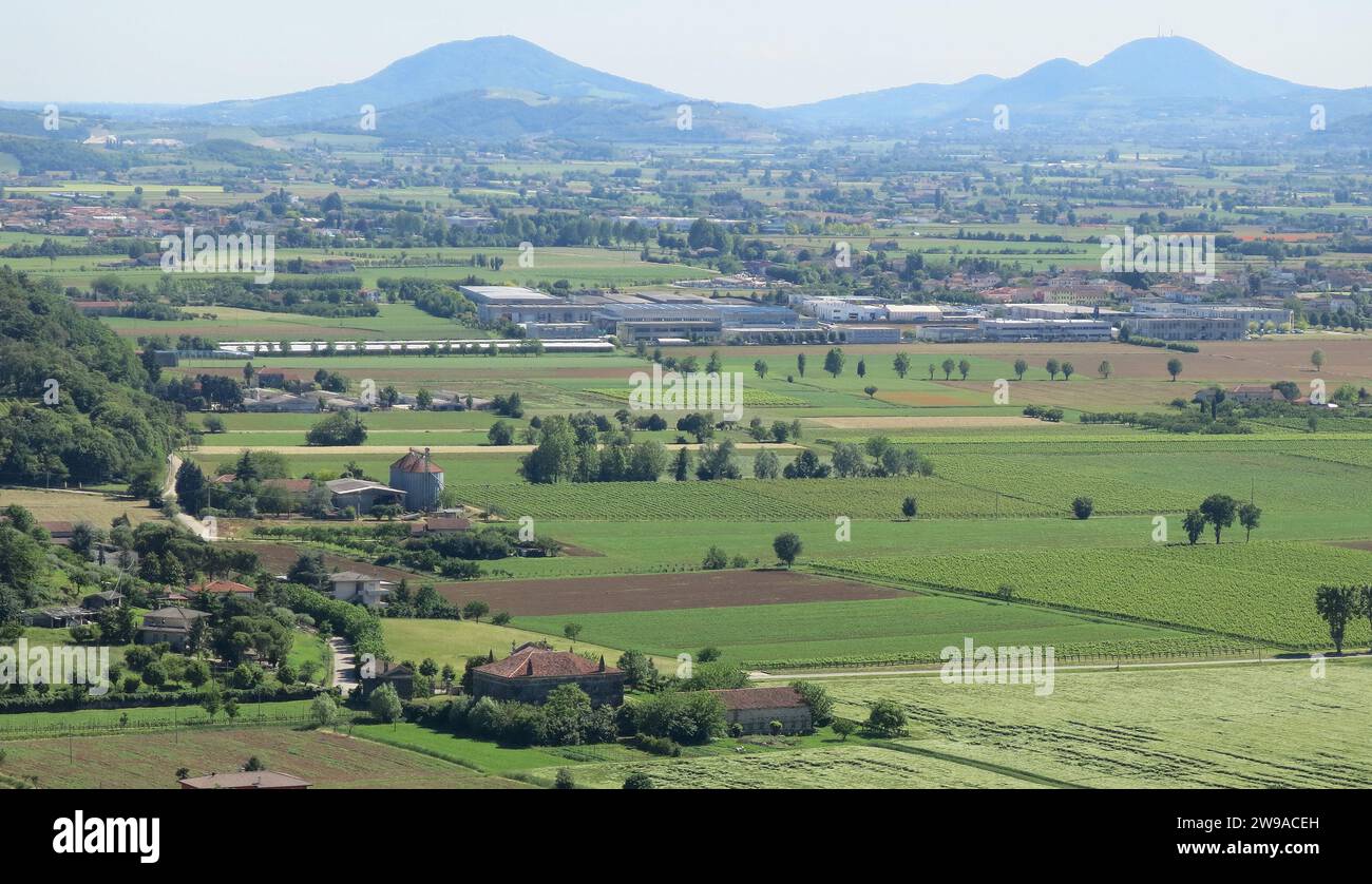 Suggestiver Blick von oben auf die Kulturfelder mit geometrischen Formen in der Ebene mit den Bergen im Hintergrund Stockfoto