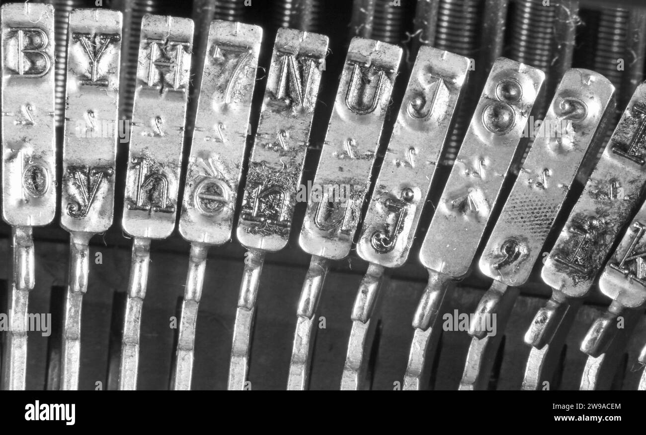 Detail des Schreibmaschinenhammers aus Edelstahl mit geprägten Buchstaben in Schwarz-weiß Stockfoto