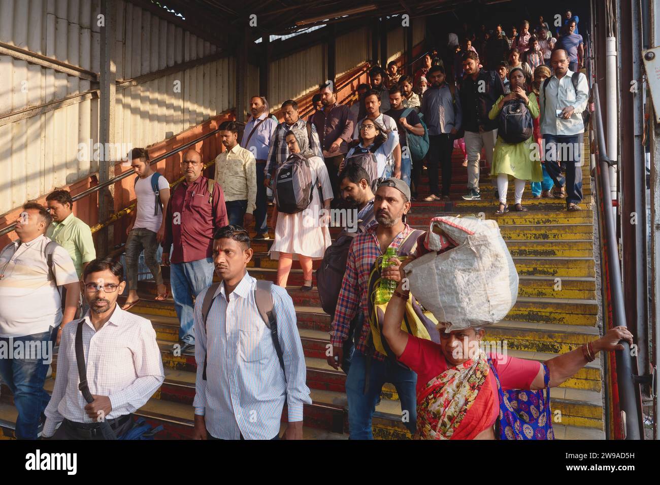 Während der Rush Hour am Vormittag steigt ein Haufen von Mumbai-Eisenbahnfahrern eine Treppe hinab, um einen Bahnsteig am Dadar-Bahnhof in Mumbai, Indien, zu erreichen Stockfoto