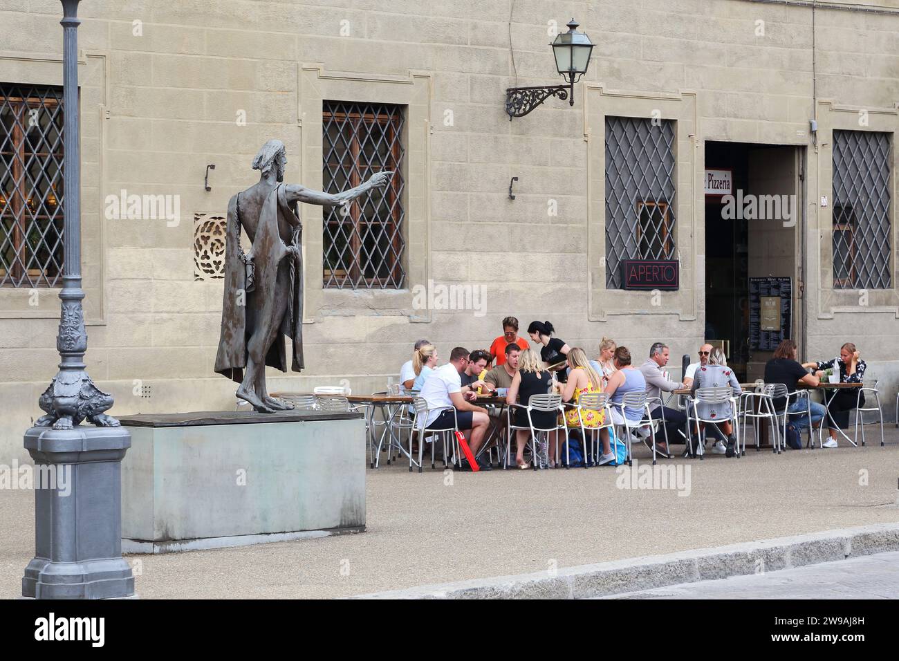 FLORENZ, ITALIEN - 13. SEPTEMBER 2019: Nicht identifizierte Menschen essen in einem Café am Ufer in der Nähe des modernen Denkmals für Johannes den Täufer. Stockfoto