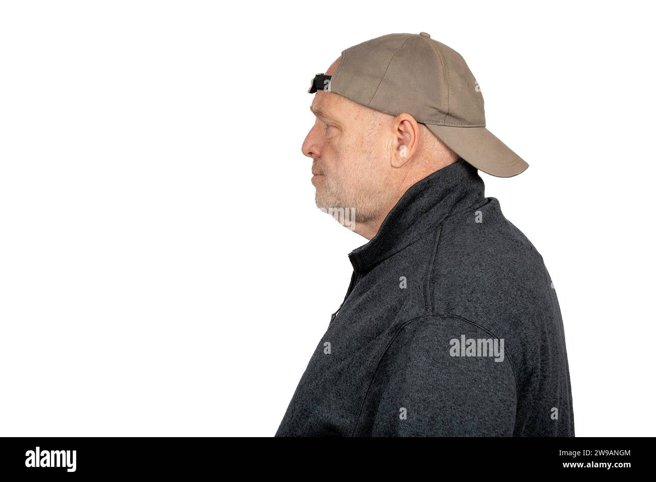 Unsicherer kaukasischer Mann mittleren Alters in Backward Baseball Cap auf weißem Hintergrund - reflektierendes Konzept für Blue Collar Arbeiter und Wähler. Stockfoto