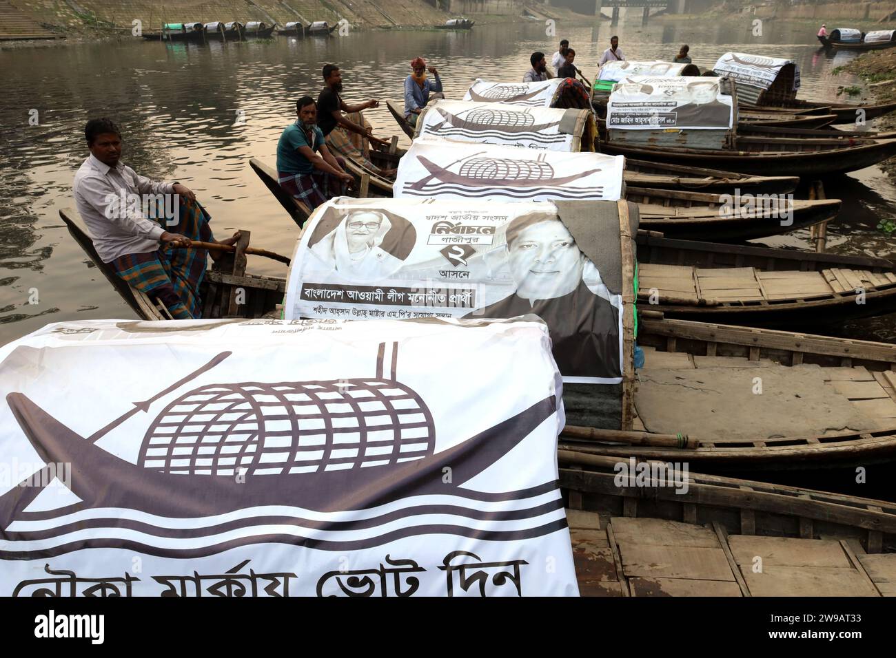 Tongi, Gazipur, Bangladesch. Dezember 2023. Im Rahmen der Wahlkampagne von Zahid Ahsan Russell, dem ausgewählten Kandidaten der Bangladesch Awami League für den Sitz von Gazipur-2 bei den bevorstehenden Parlamentswahlen, werden Parteibanner auf Passagierschiffen im Fluss Turag angebracht. (Kreditbild: © Syed Mahabubul Kader/ZUMA Press Wire) NUR REDAKTIONELLE VERWENDUNG! Nicht für kommerzielle ZWECKE! Stockfoto