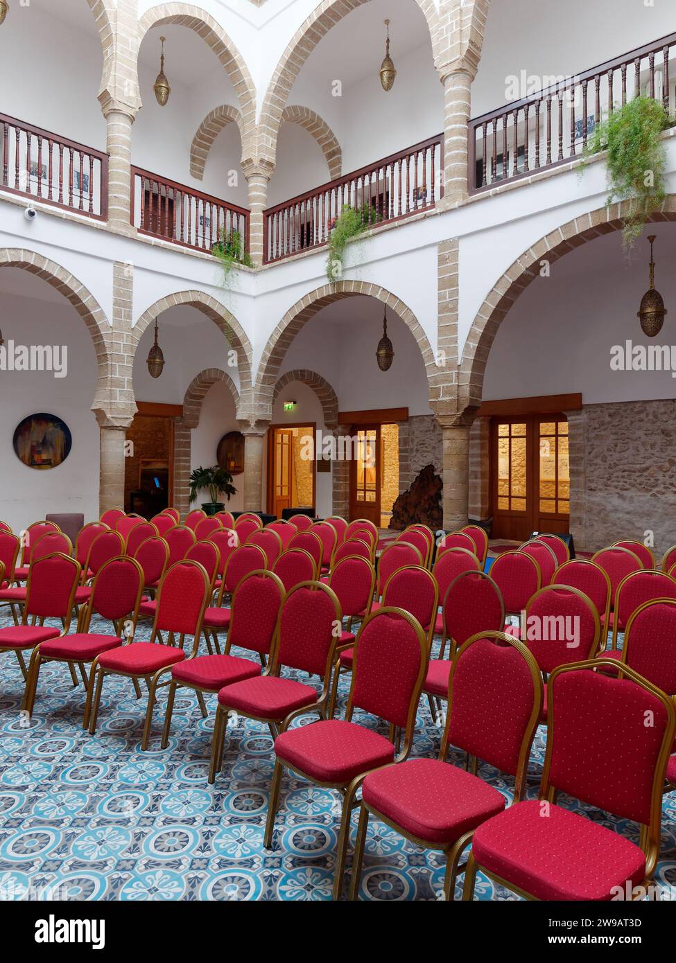 Konzerteinrichtung mit roten Stühlen und Balkon in Essaouira, Marokko. Dezember 2023 Stockfoto