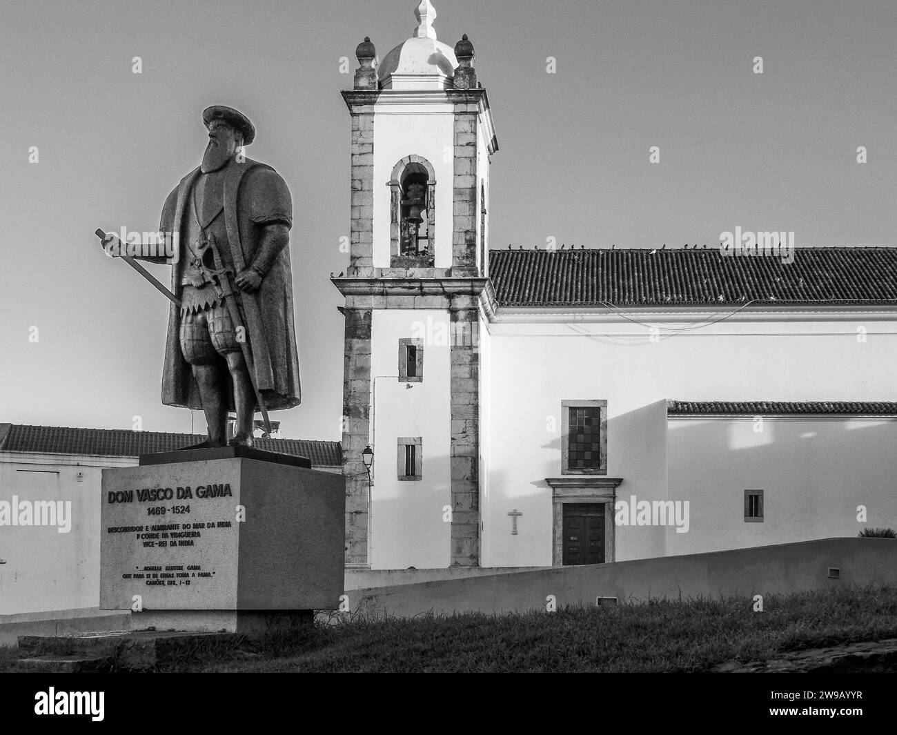 Statue von Dom Vasco da Gama mit der katholischen Kirche Igreja Matriz do Salvador de Sines in der Stadt Sines in der Region Costa Azul in Portugal Stockfoto