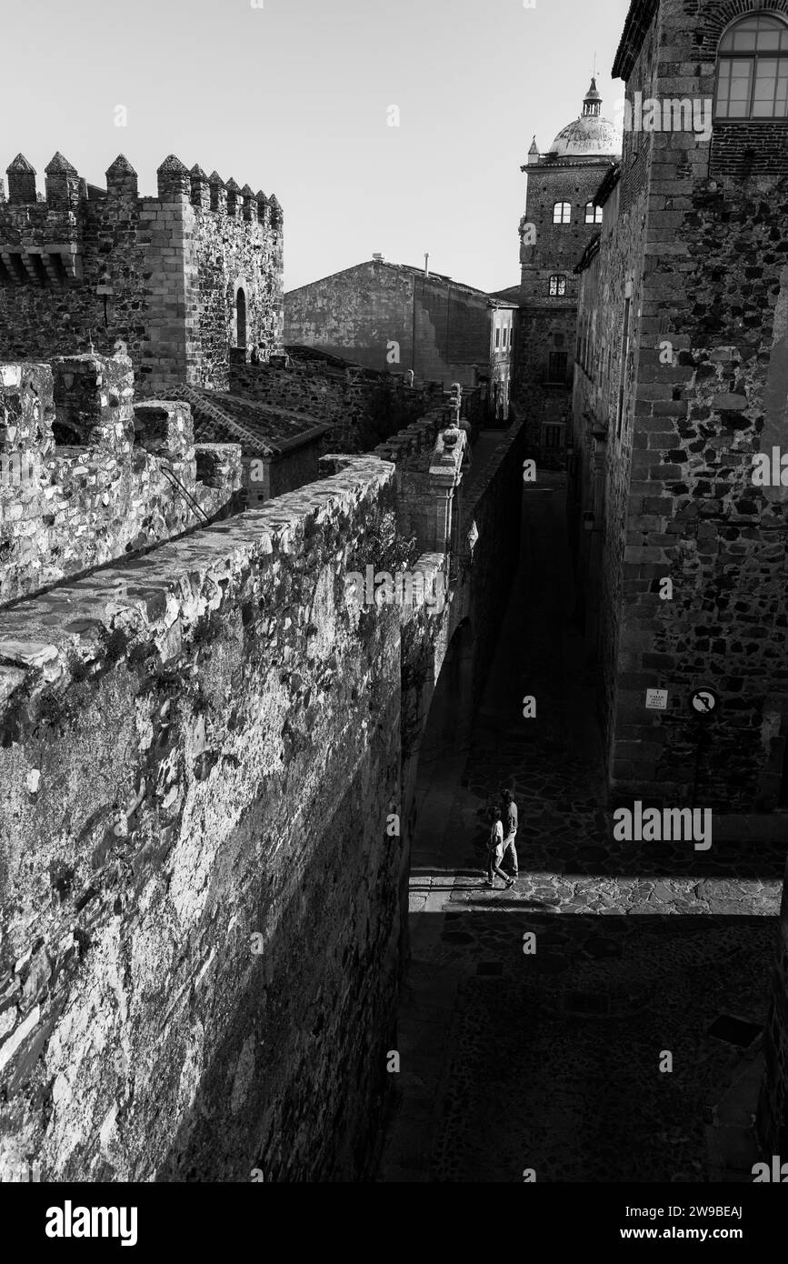 Schwarzweiß-Bild mit Blick hinter den Verteidigungsmauern der mittelalterlichen Stadt Caceres, Extremadura, Spanien. Stockfoto