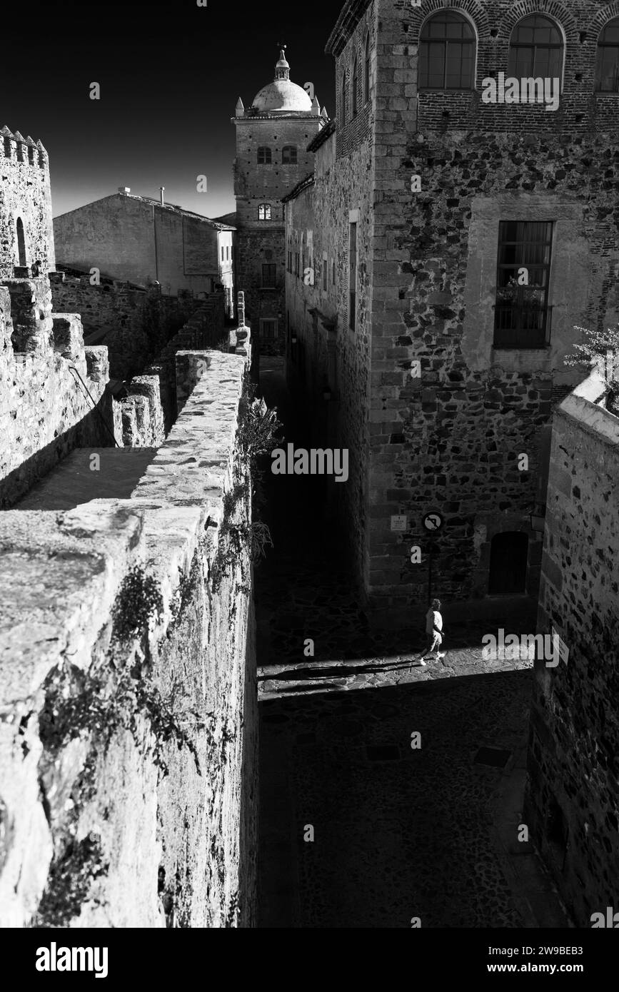 Schwarzweiß-Bild mit Blick hinter den Verteidigungsmauern der mittelalterlichen Stadt Caceres, Extremadura, Spanien. Stockfoto