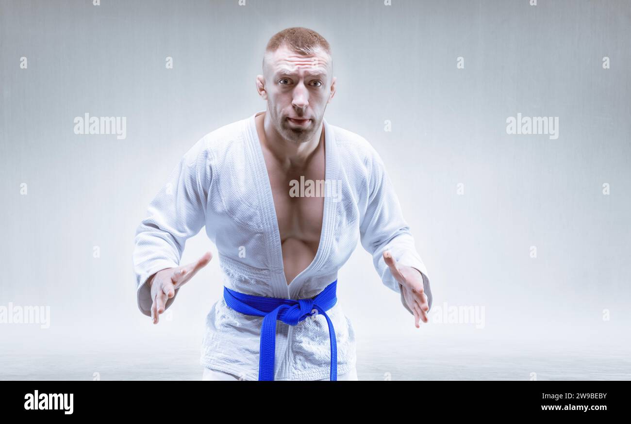 Sportler im Kimono mit blauem Gürtel. Das Konzept der Karate- und Judowettbewerbe. Gemischte Medien Stockfoto