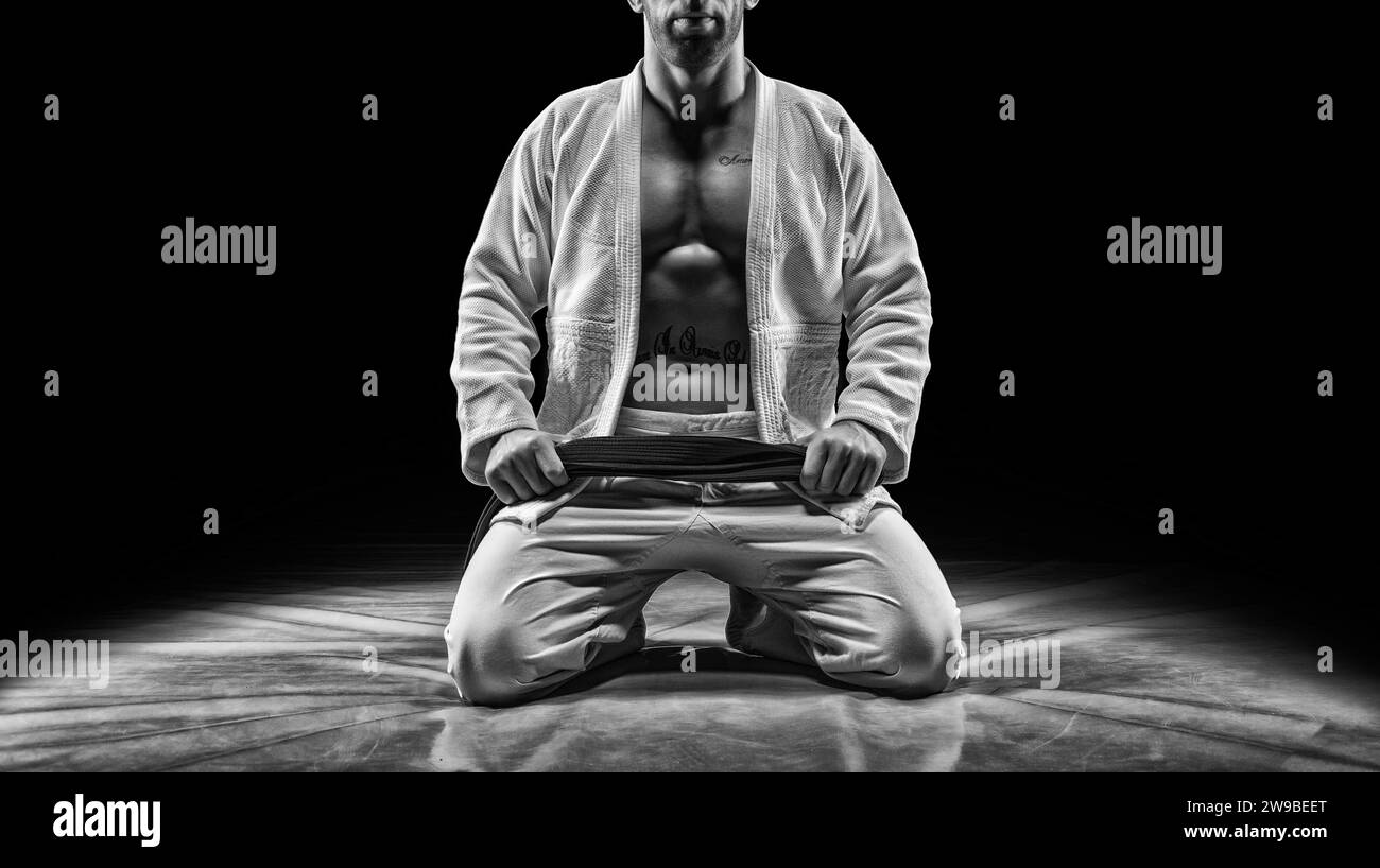 Profi-Athlet sitzt im Fitnessstudio. Konzept von Karate, Jiu-Jitsu, Sambo, Judo. Gemischte Medien Stockfoto