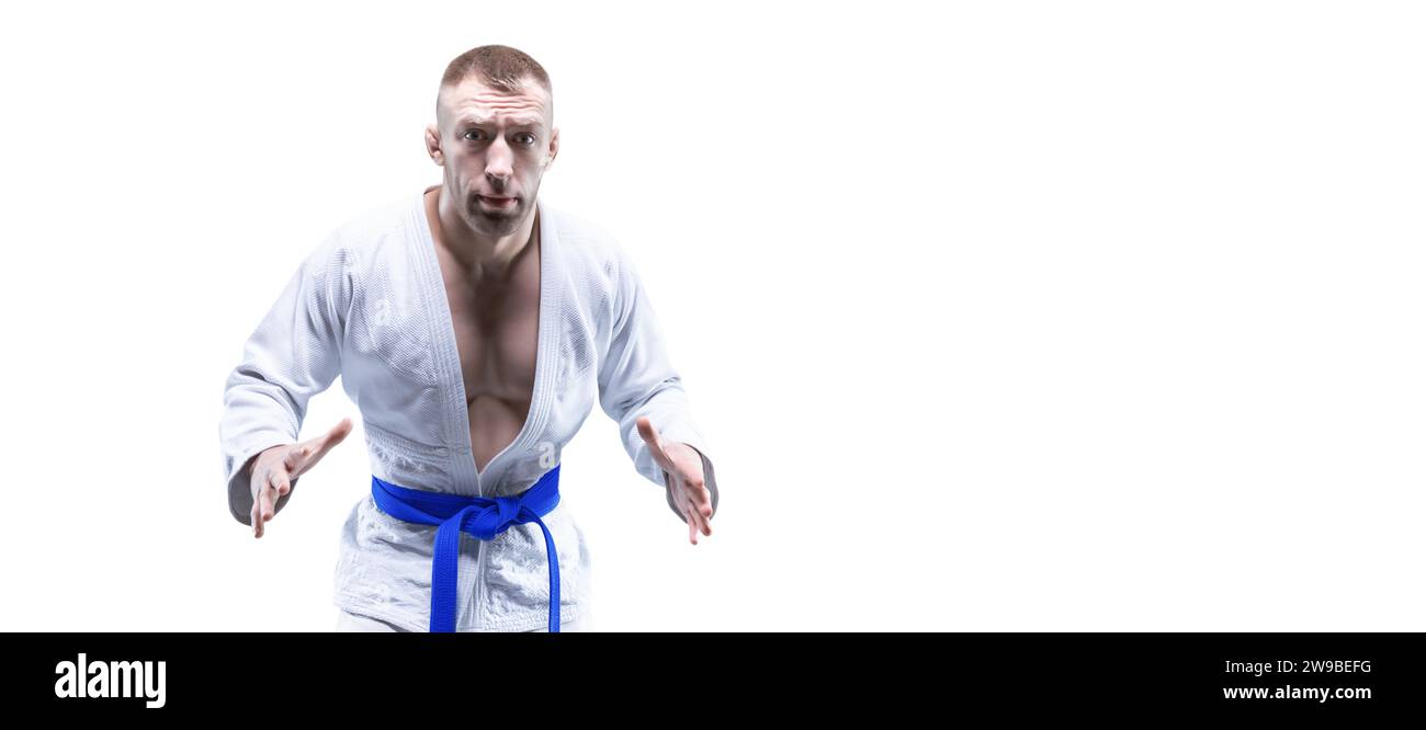 Sportler im Kimono mit blauem Gürtel. Weißer Hintergrund. Das Konzept der Karate- und Judowettbewerbe. Gemischte Medien Stockfoto