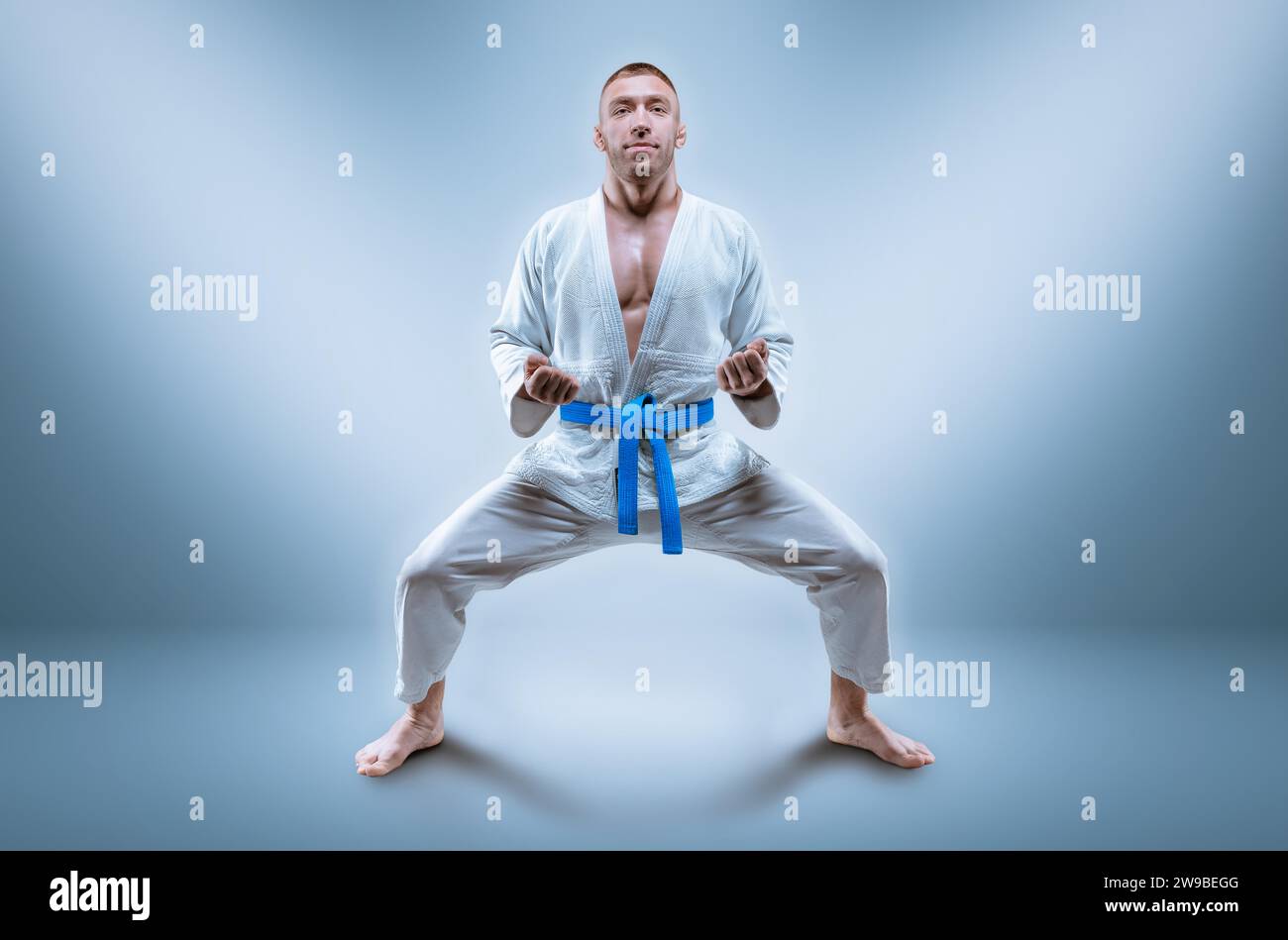 Professioneller Wrestler trägt einen Kimono. Er bereitet sich darauf vor, die Kata zu demonstrieren. Das Konzept der gemischten Kampfkunst, Karate, Sambo, Judo, Jujitsu. M Stockfoto