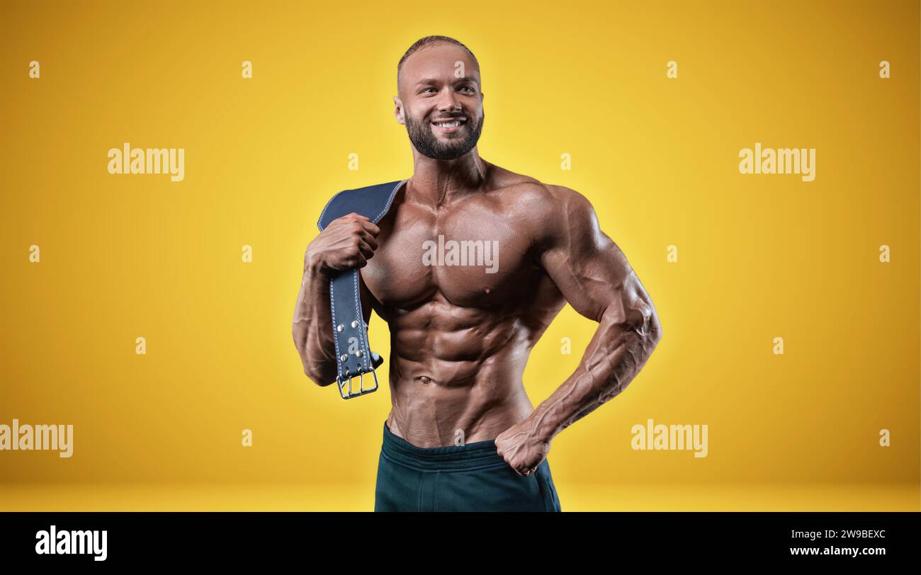 Isolierter Profisportler auf gelbem Hintergrund. Bodybuilding-Konzept. Panorama. Werbung für ein Fitnessstudio und Sporternährung. Gemischte Medien Stockfoto