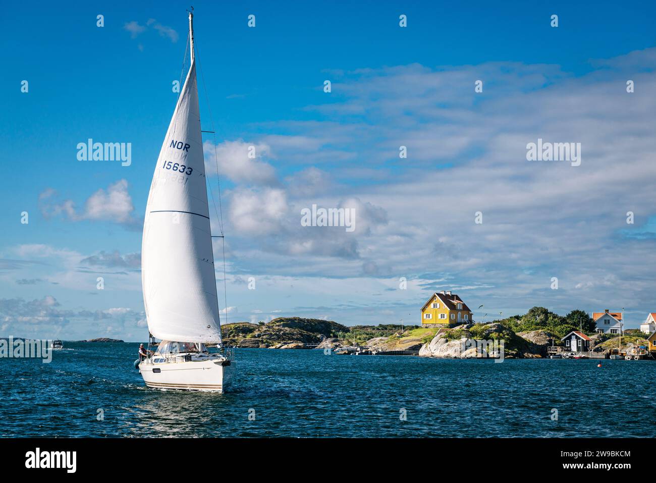 Eine Yacht mit einem Topsegel, die durch den Sound zwischen den Inseln Tjörn und Härön bei Kyrkesund, dem Archipel der schwedischen Westküste, segelt Stockfoto