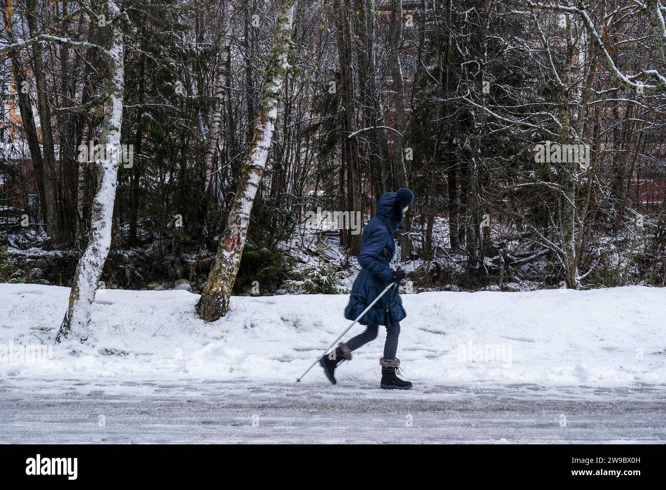 Dezember Schnee in Chamonix Centre-ville, Französisch alpen Resort, Haute Savoie, Frankreich. Frau wandert auf der Straße. Stockfoto