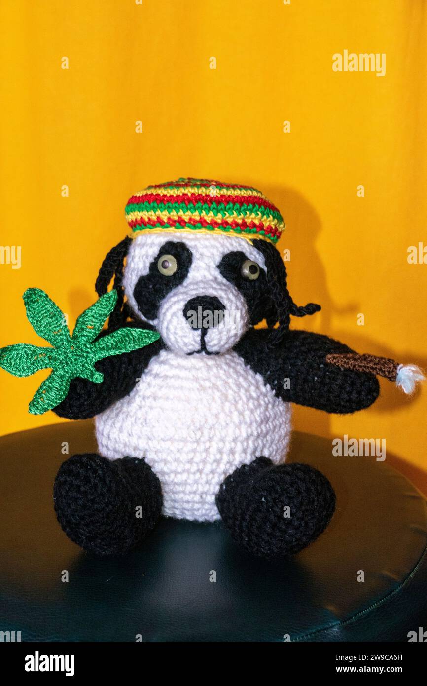 Gehäkelter Reggae Panda Bär mit Jamaika Mütze, Hanf Blatt und Rasterlöckchen Stockfoto