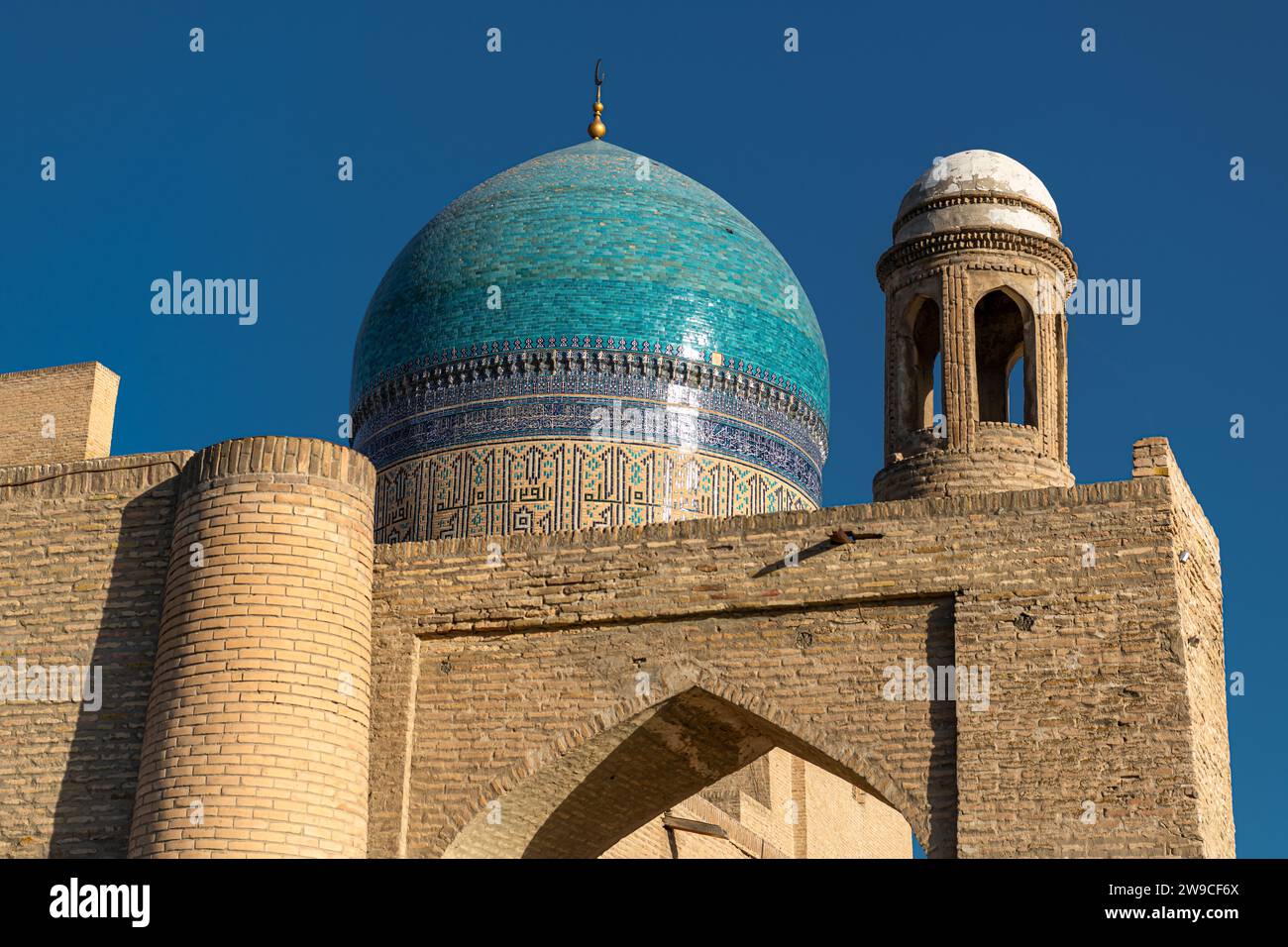 27. JUNI 2023, BUCHARA, USBEKISTAN: Blick auf die Kuppel und den Turm der Poi Kalon Moschee bei Sonnenuntergang in Buchara, Usbekistan. Horizontales Bild mit Kopien Stockfoto