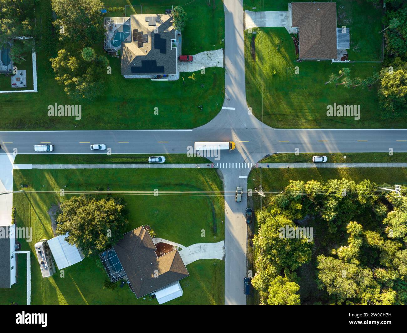 Draufsicht auf den klassischen gelben schulbus der usa, der auf der Straße der ländlichen Stadt fährt, um Kinder für ihre kleinen Kinder am frühen Morgen abzuholen. Öffentlich Stockfoto