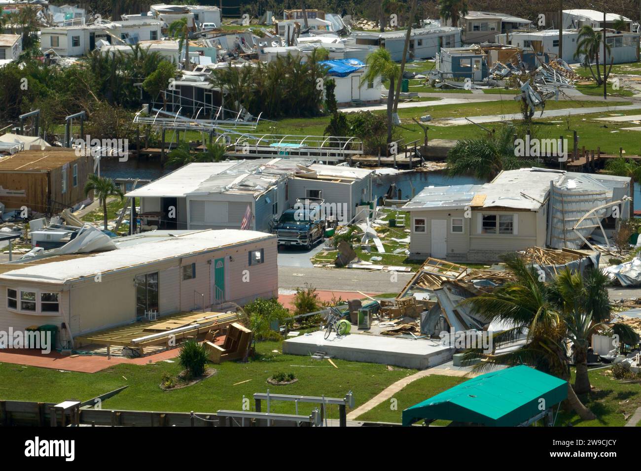 Blick von oben auf die durch den Hurrikan Ian zerstörten Vorstadthäuser in Florida mobiles Wohngebiet. Folgen von Naturkatastrophen Stockfoto