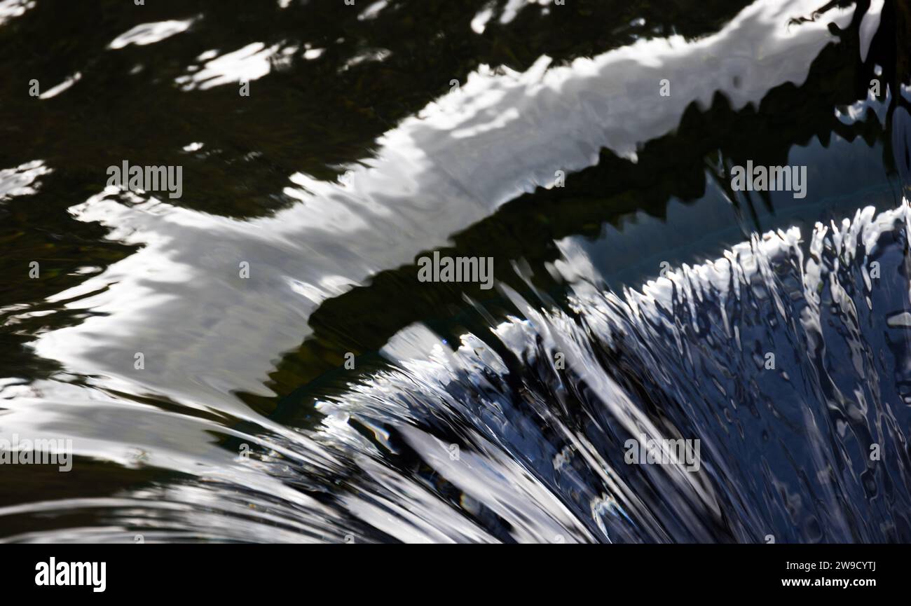 Fließendes Wasser mit Reflektionsmuster. Natürliches abstraktes Hintergrundfoto Stockfoto