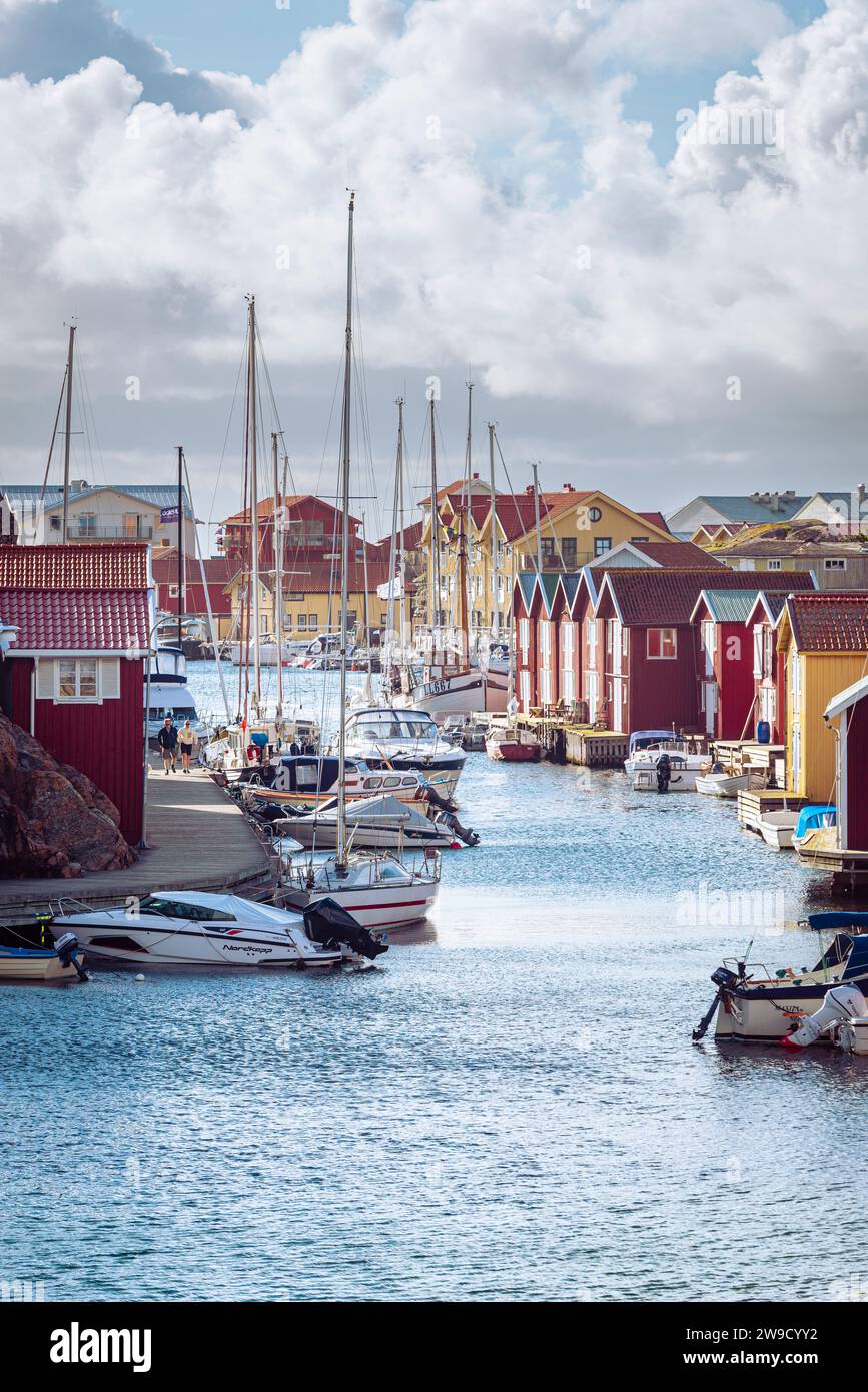 Bootsschuppen und Lagerhäuser mit roten Holzfassaden und Granitfelsen im Hafen von Smögen im Archipel der schwedischen Westküste Stockfoto