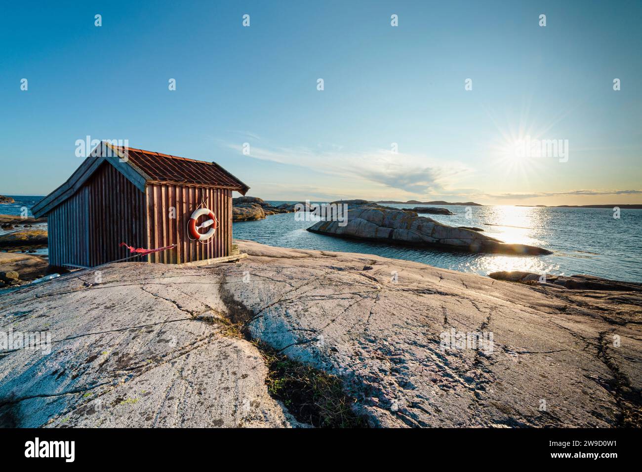 Holzhütte auf den Felsen im Naturschutzgebiet Tjurpannan im Archipel der schwedischen Westküste, beleuchtet von der Abendsonne Stockfoto