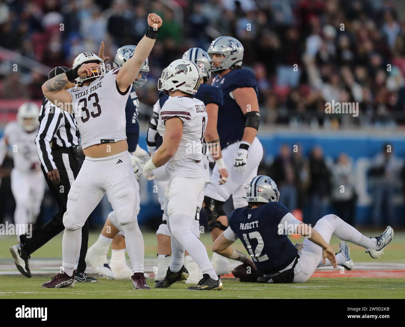 Dallas, Texas, USA. Dezember 2023. BEN BELL (33) feiert einen Sack auf dem Rice Quarterback AJ PADGETT (12 auf dem Boden) während des First Responders Bowl am Dienstag im Gerald J. Ford Stadium auf dem SMU Campus in Dallas, Texas. Texas State besiegte 45 die Rice University. (Kreditbild: © Brian McLean/ZUMA Press Wire) NUR REDAKTIONELLE VERWENDUNG! Nicht für kommerzielle ZWECKE! Stockfoto