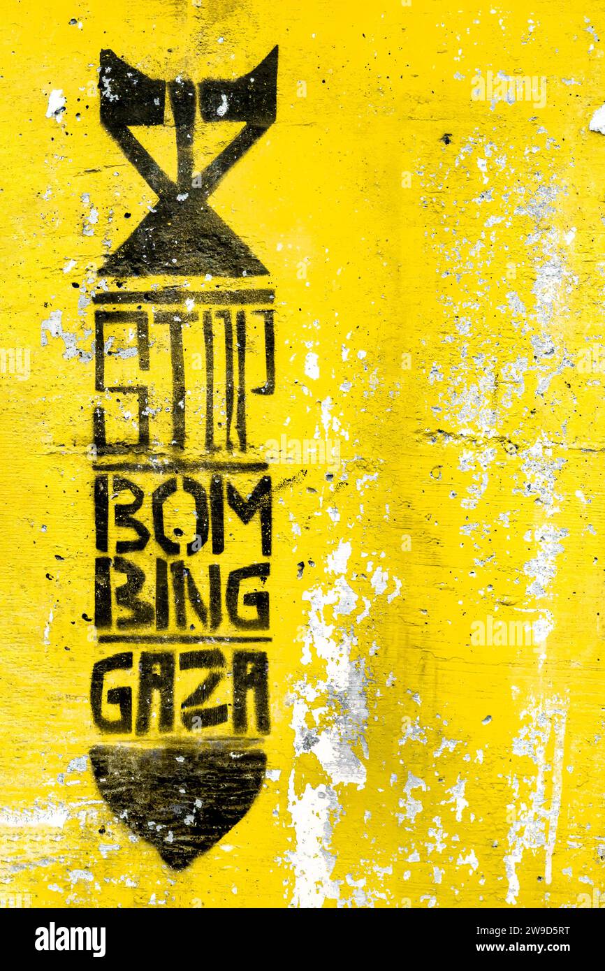 Graffiti auf der gelben grungy Wand, die die Silhouette einer Bombe darstellt. Text innen: STOP BOMBING GAZA. Kopierbereich. Vollständig bearbeitbar. Stockfoto