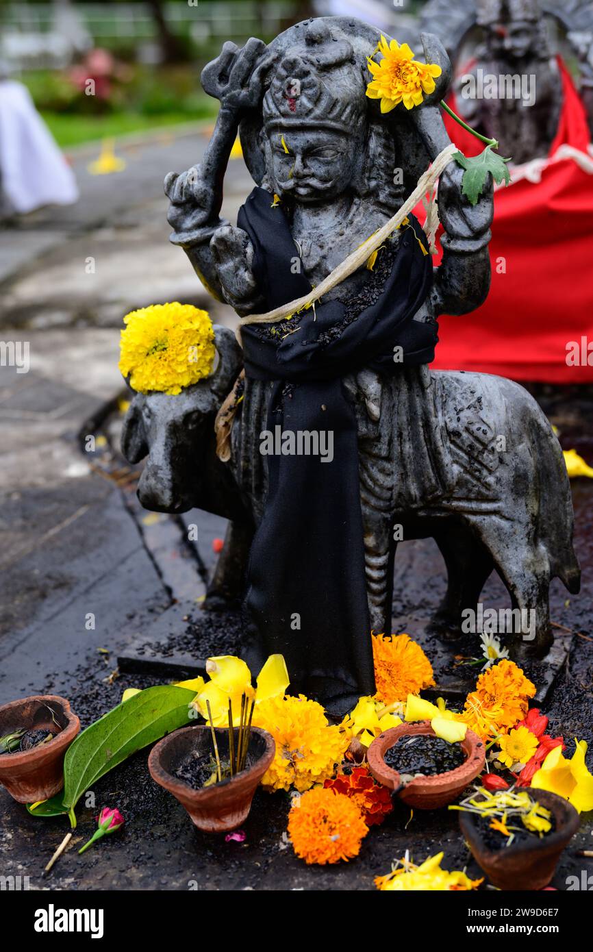 Shani Dev Hindu God Statue in Grand Bassin oder Ganga Talao, Mauritius mit Blumenopfer oder Opfer Stockfoto