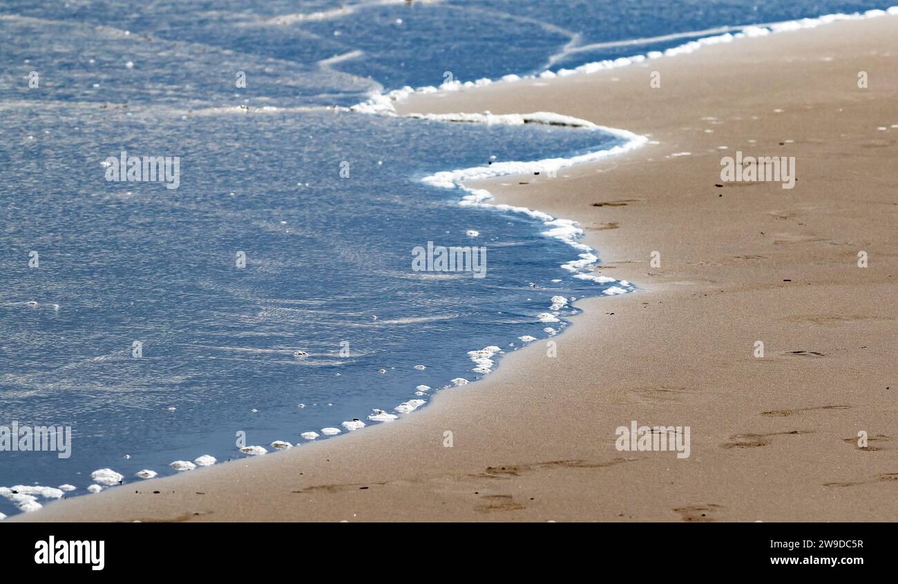 Linie zwischen Wasser und Land am Strand von Denia Stockfoto