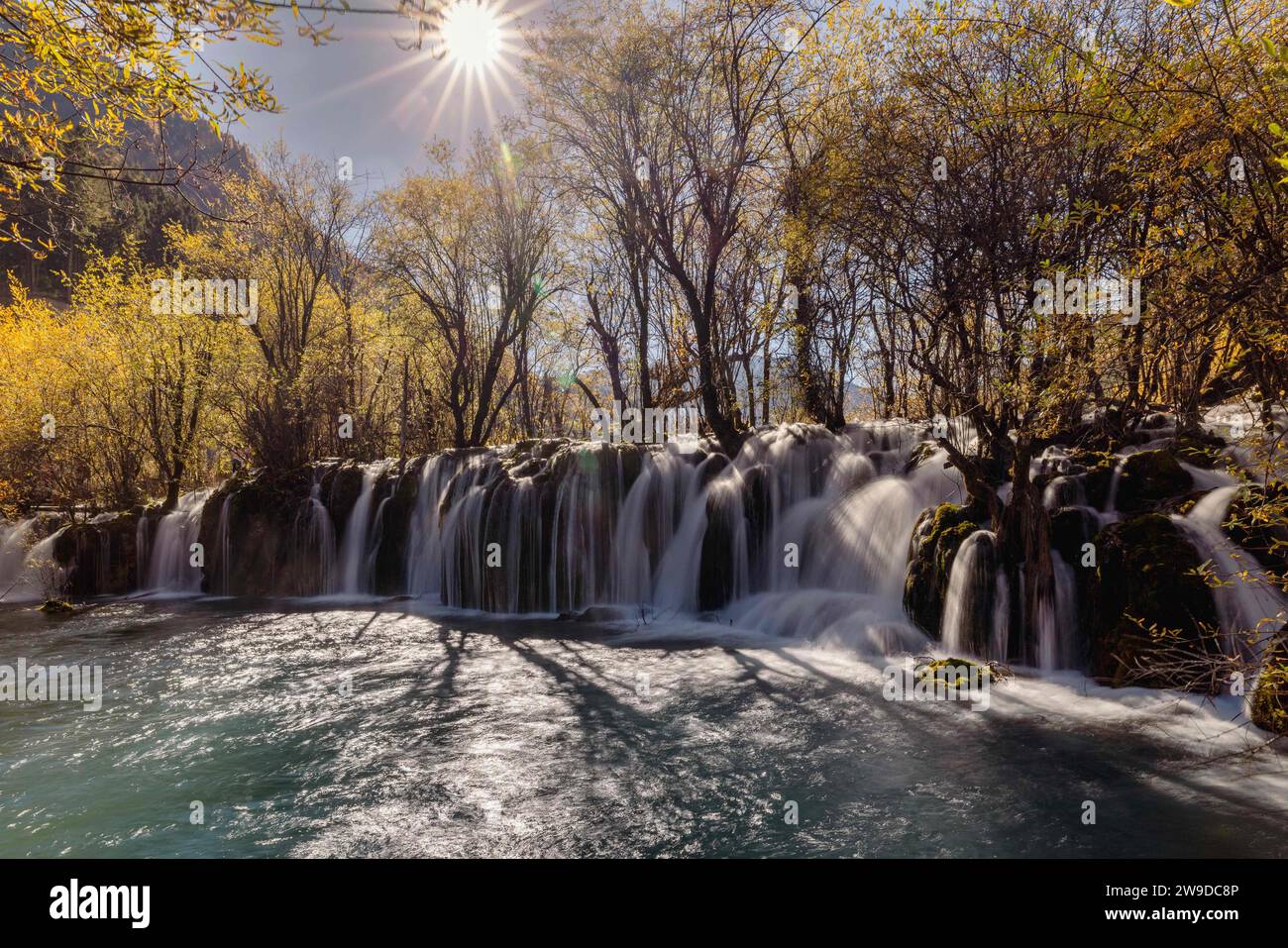 Ein malerischer Blick auf einen Wasserfall, der im Herbst einen bewaldeten Berg hinunterstürzt Stockfoto