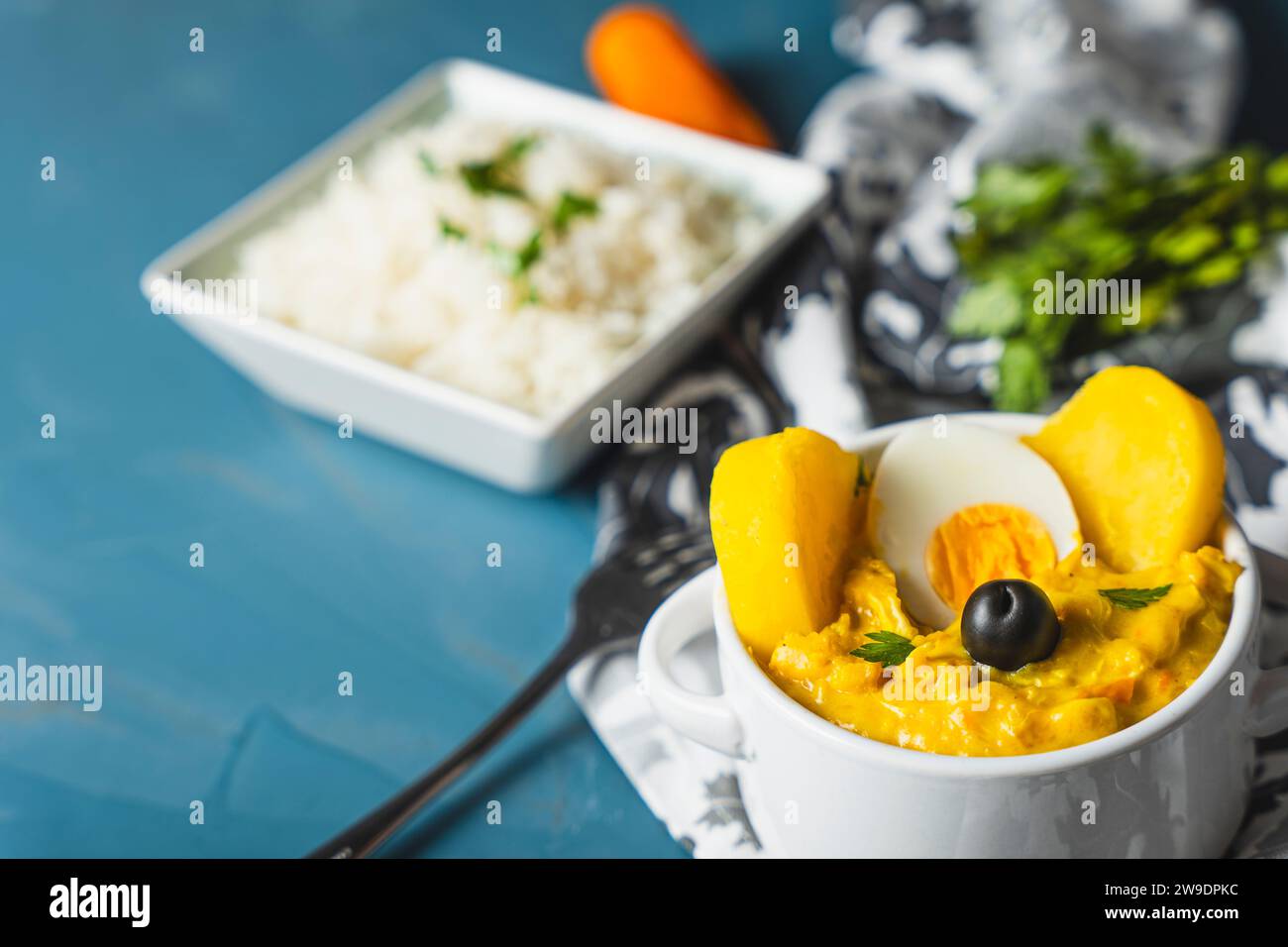 Traditionelles Gericht namens Aji de gallina mit einer Portion Reis, sehr beliebt in der peruanischen Gastronomie. Stockfoto