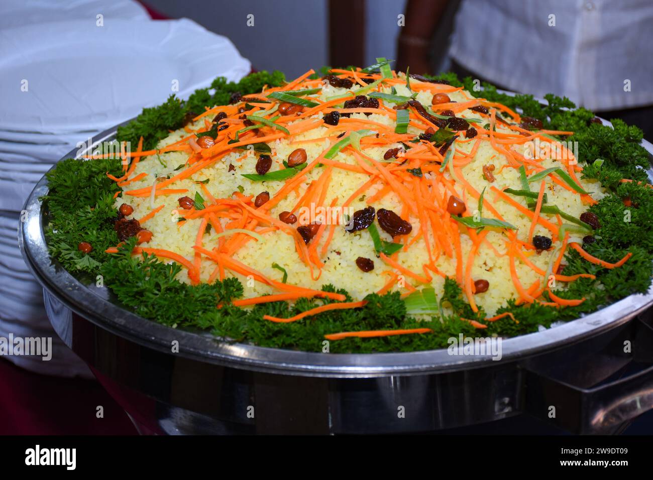 Gelber Reis mit buntem Gemüse als Salat am Buffet. Farbenfrohe Dekoration Stockfoto