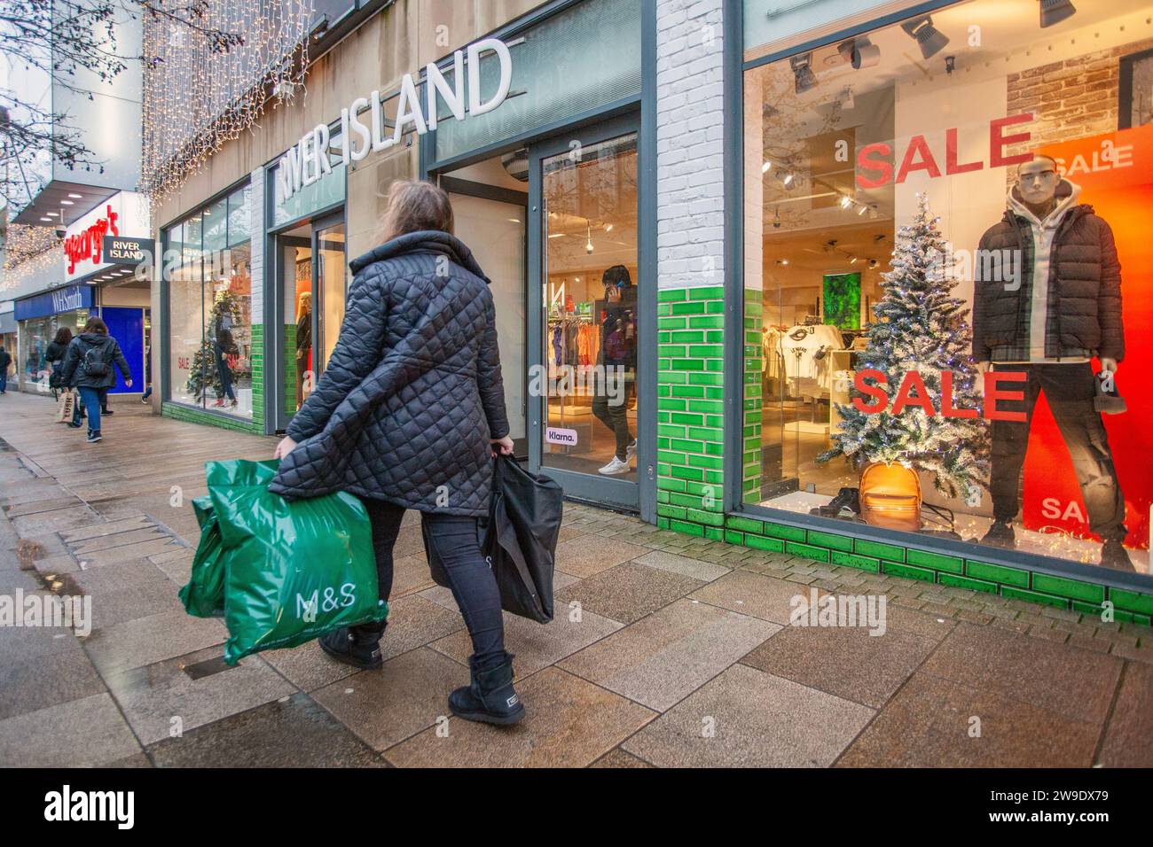 River Island Modegeschäft in Preston, Lancashire. Wetter in Großbritannien. Dezember 2023. Weihnachtsgeschäfte, Shopper shoppen an einem nassen und böigen Tag im Stadtzentrum. Credit MediaWorldImages/AlamyLiveNews Stockfoto