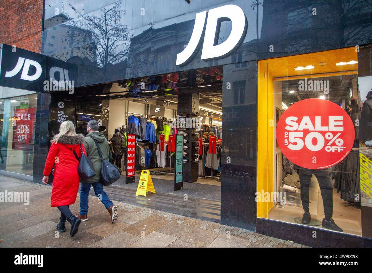 JD Sports 50 % Rabatt auf Sale Footwear Store in Preston, Lancashire. Wetter in Großbritannien. Dezember 2023. Weihnachtsgeschäfte, Shopper shoppen an einem nassen und böigen Tag im Stadtzentrum. Credit MediaWorldImages/AlamyLiveNews Stockfoto